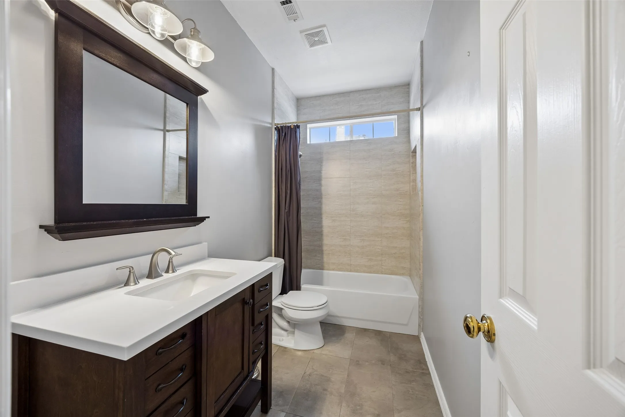 Bathroom vanity featuring a white countertop, undermount sink, and brushed nickel faucet