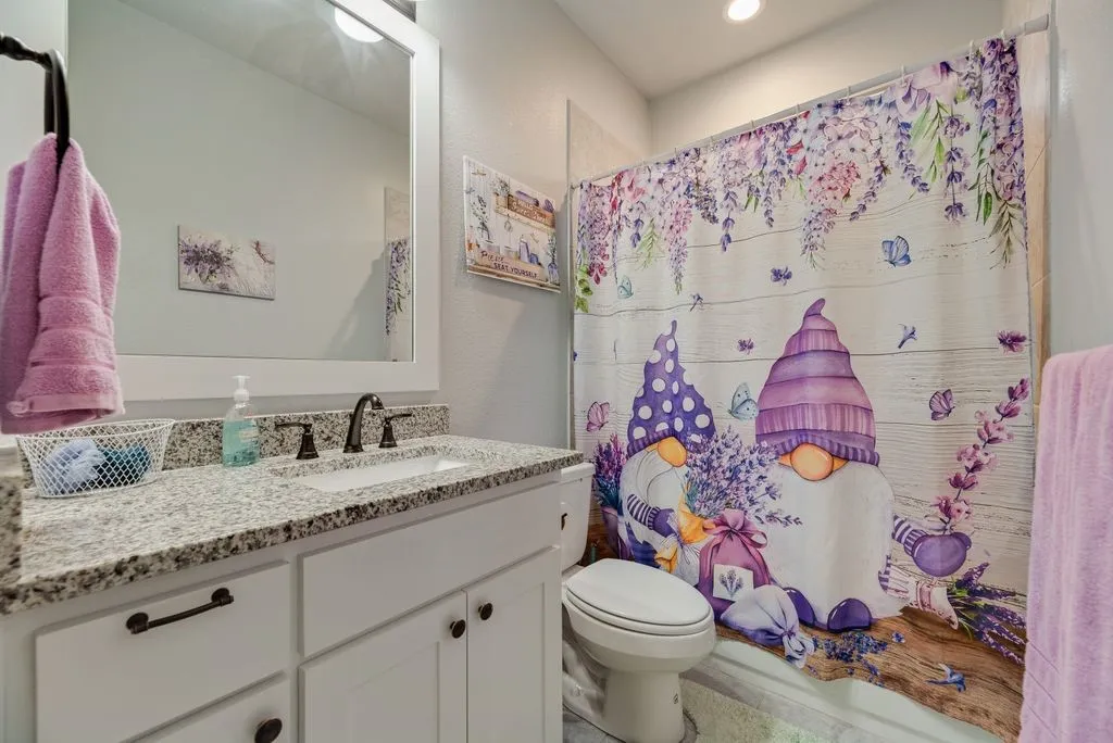Bathroom featuring a white vanity with granite-style countertop, undermount sink, and dark bronze-finish fixtures