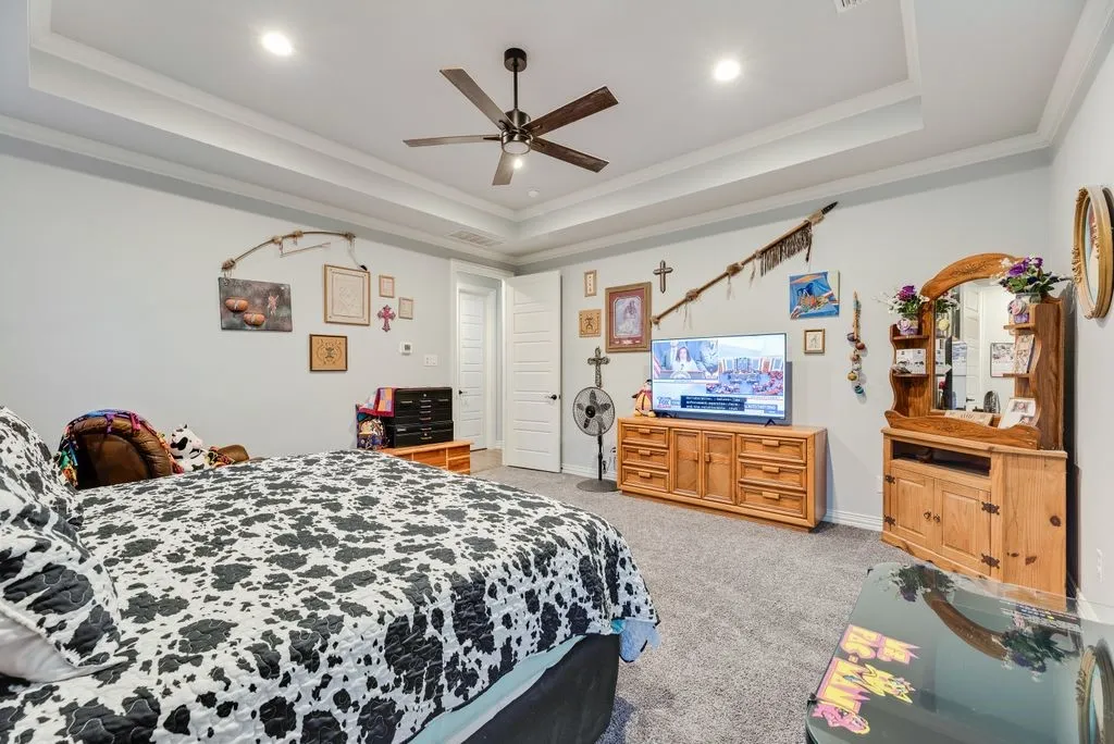 Tray ceiling with recessed lighting, ceiling fan, and carpeted flooring