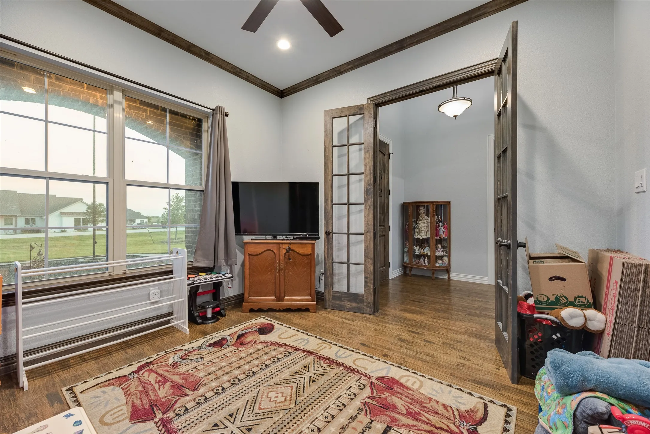 Wood-finish flooring throughout, featuring a ceiling fan and recessed lighting