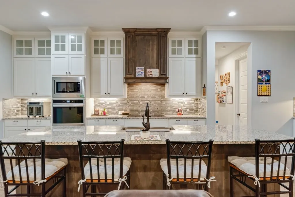 Kitchen island with a light-toned stone countertop and integrated sink