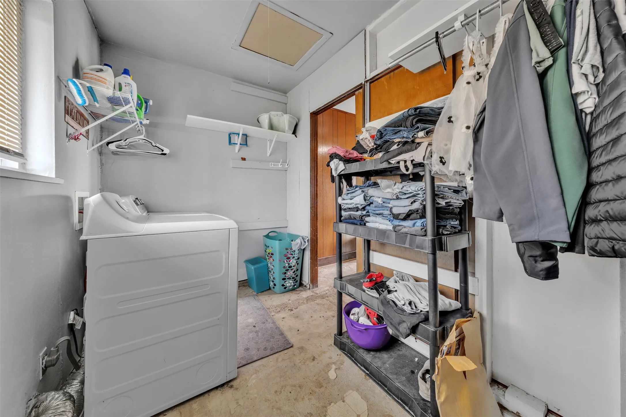 Utility room with a window, built-in shelving, and a top-loading appliance