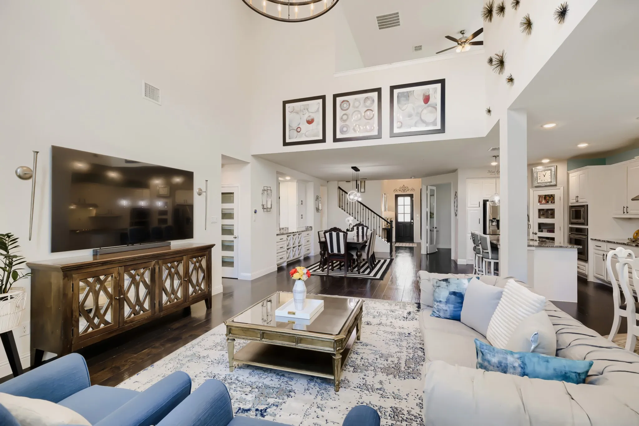 Spacious living area featuring high ceilings, dark wood-finish flooring, and white walls