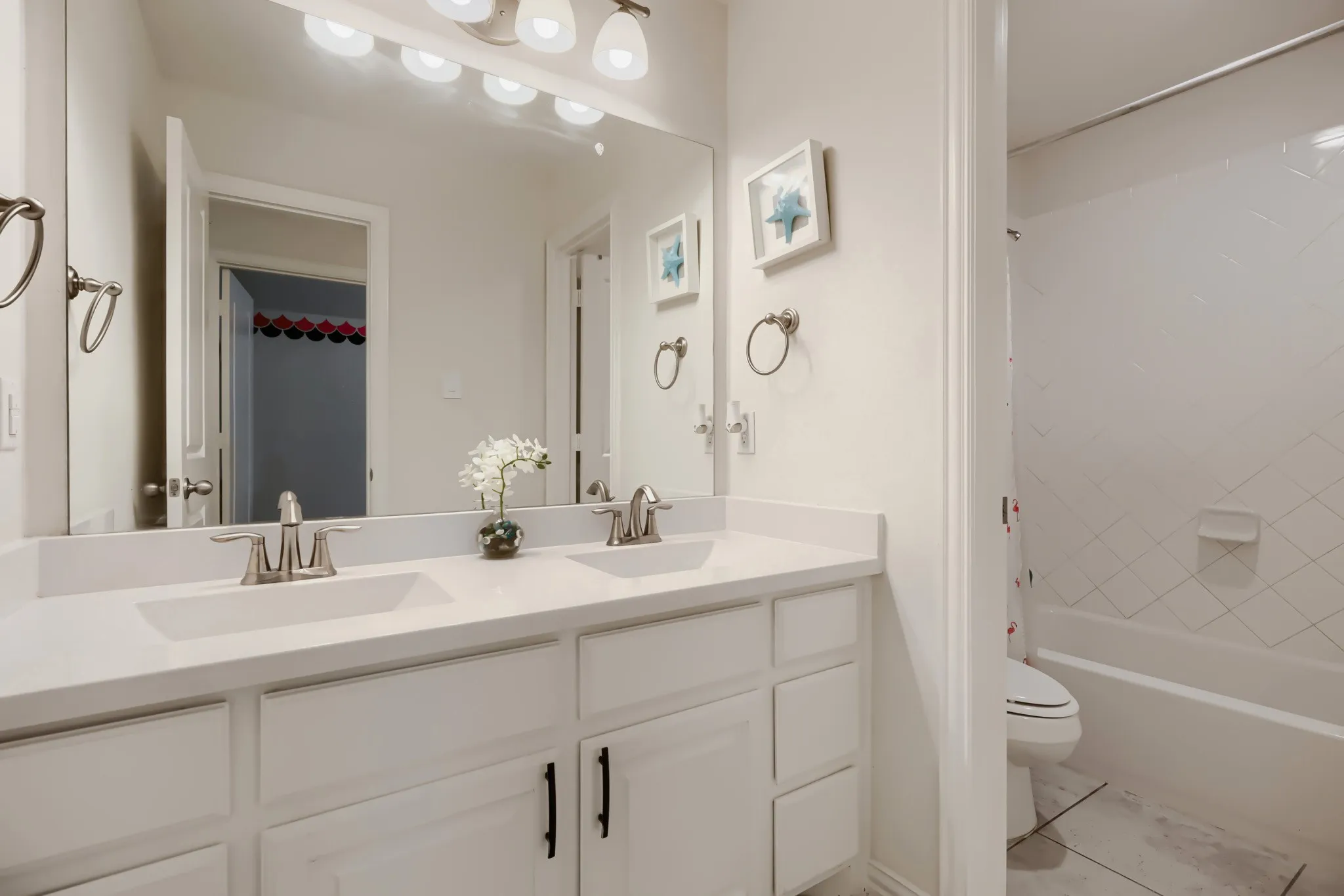Dual vanity featuring integrated sinks, white countertops, and brushed nickel faucets