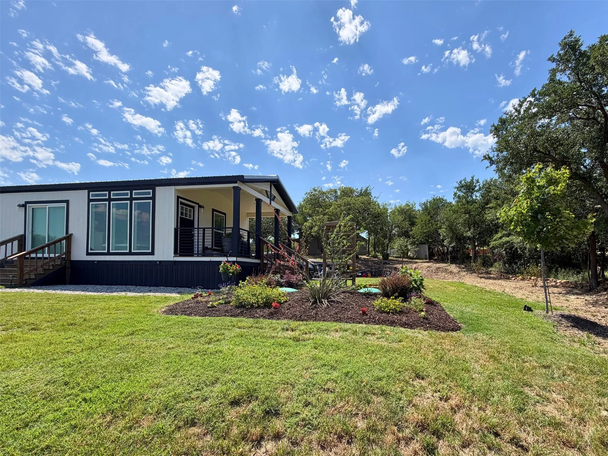  The front door covered patio is a perfect private, secluded spot to enjoy your morning coffee, with a beautiful view of the yard and lake.