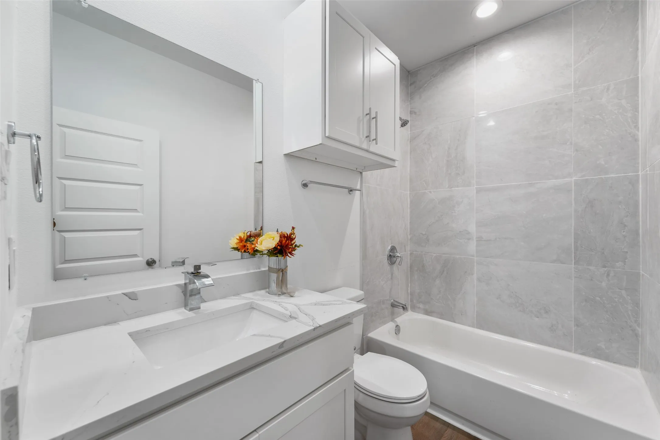 Bathroom featuring a full vanity with a rectangular undermount sink, a polished chrome faucet, and a large frameless mirror
