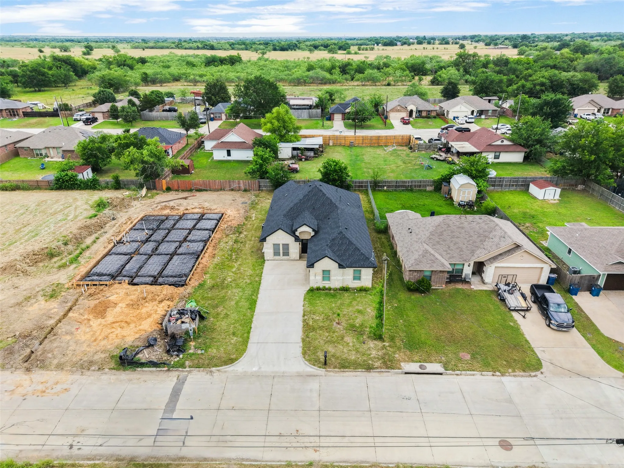 New construction site featuring a foundation slab and surrounding open land