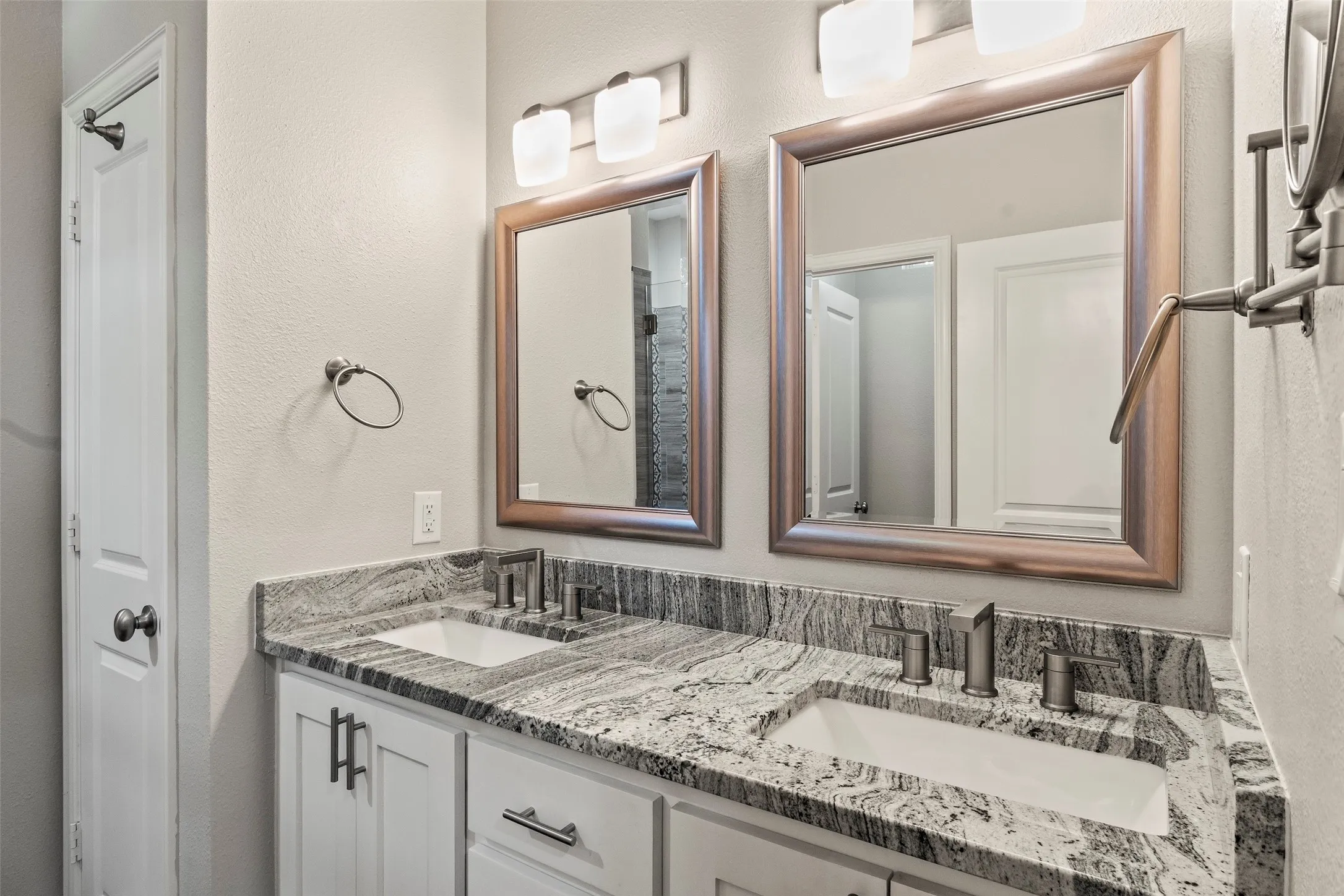 Primary bath features granite counters and a walk-in tile shower.