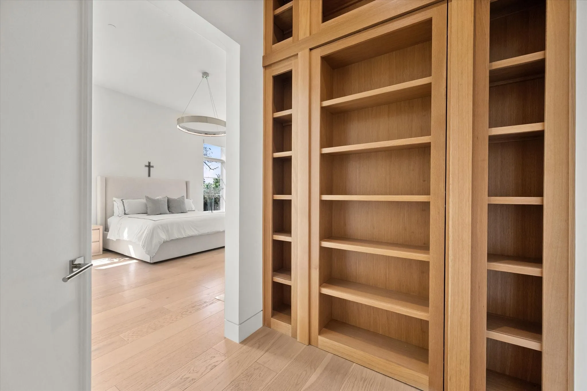 Built-in wood shelving and cabinetry with light wood finish flooring. F5-rated armored tornado shelter installed.