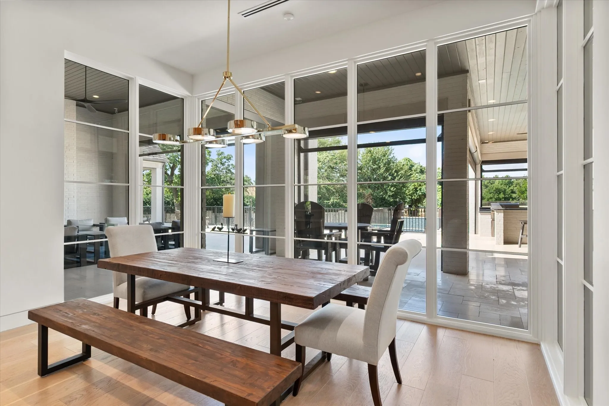 Dining area featuring light wood-finish flooring and a contemporary linear chandelier.