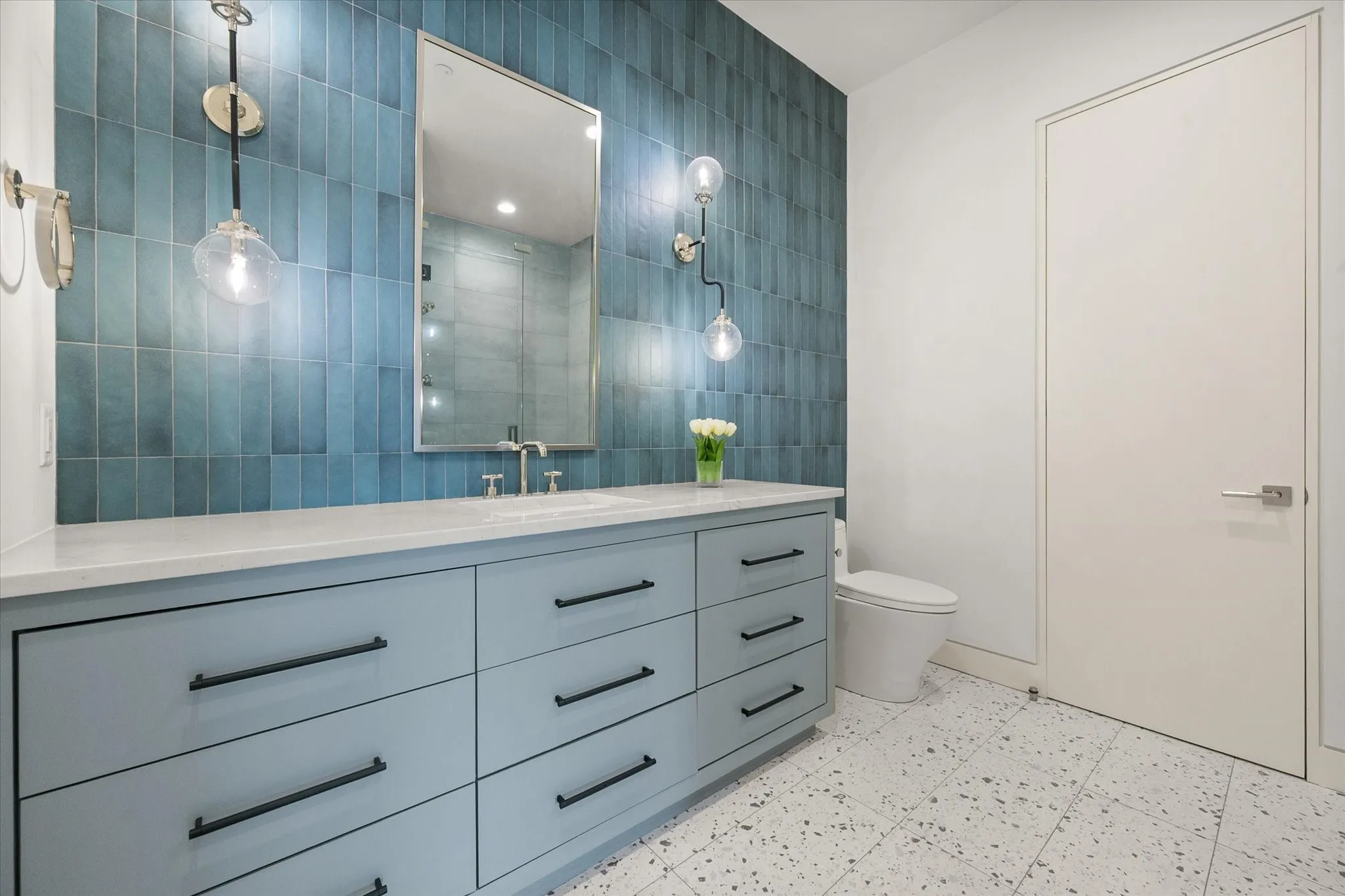 Bathroom featuring a light blue vanity with matte black hardware, white countertop, and a vessel sink