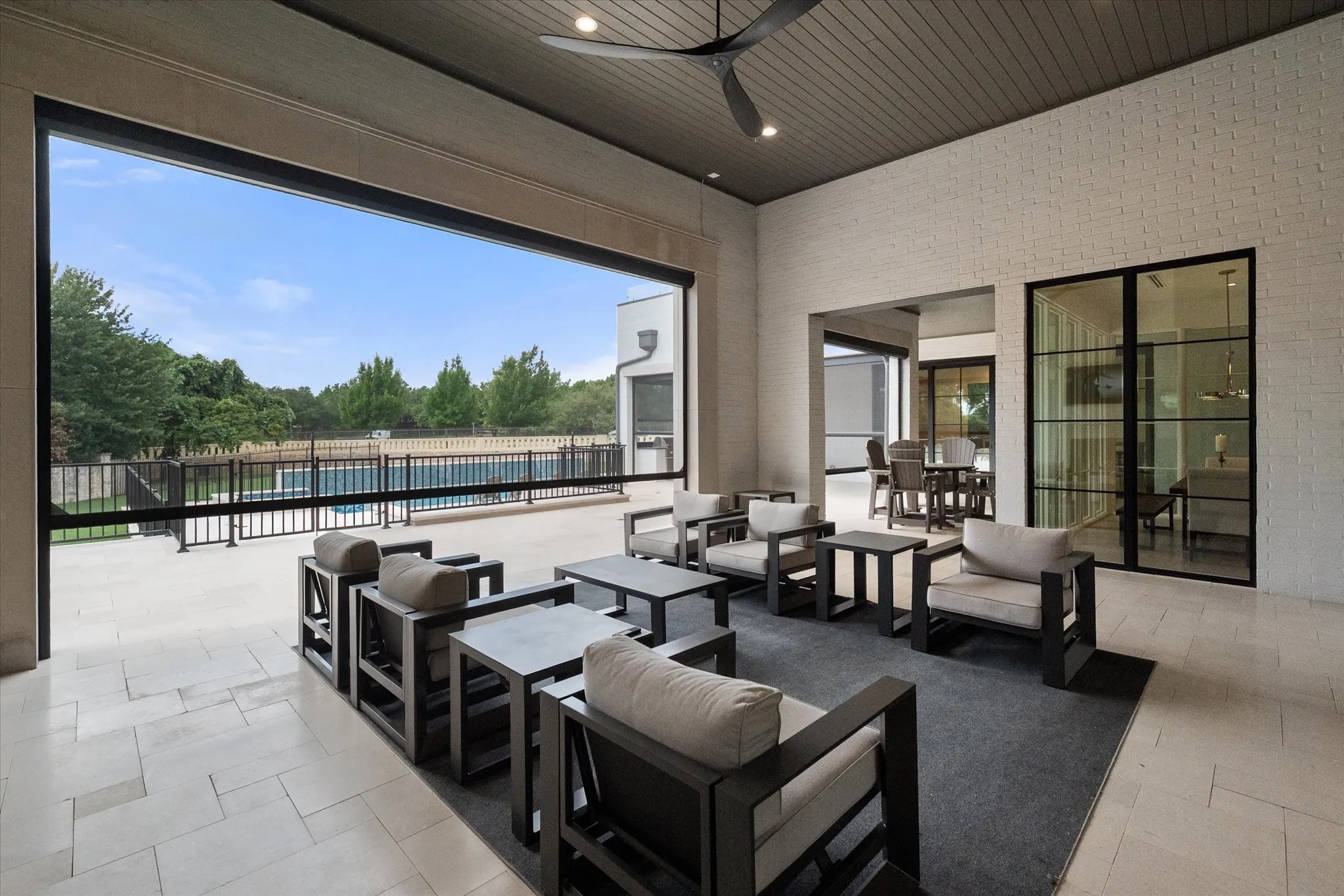 Covered patio and outdoor living area with expansive opening to outdoor pool area. Exterior backyard Phantom shade system installed at approximately $30,000 cost