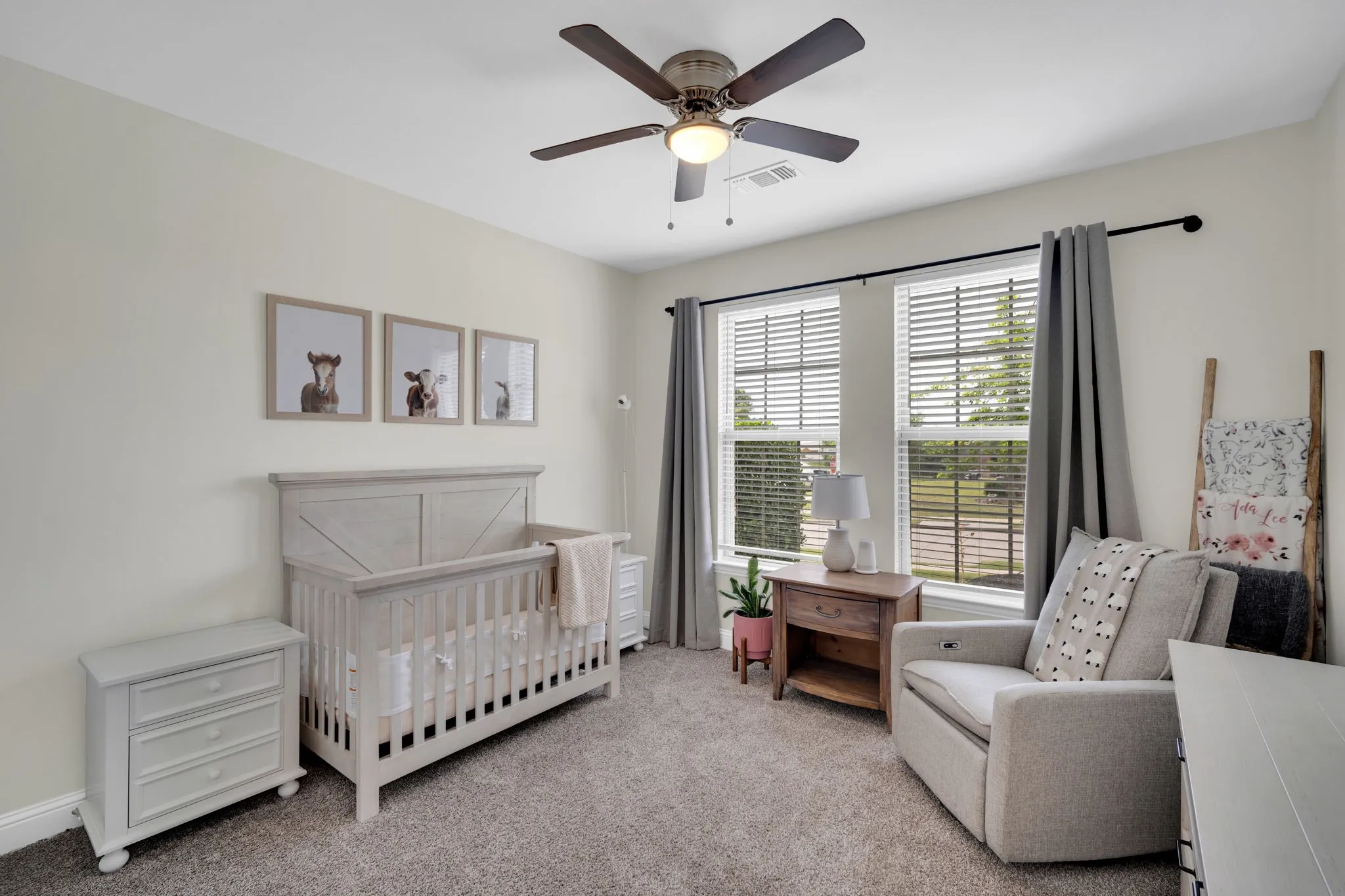 Carpeted room featuring a ceiling fan with integrated lighting, two windows with blinds and drapery, and neutral wall paint