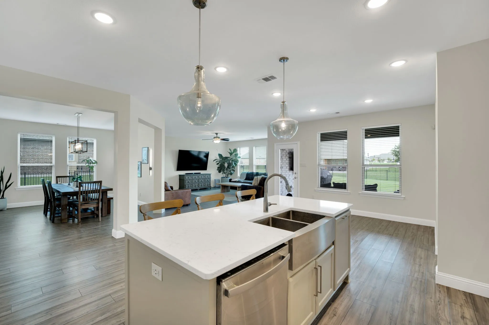 Kitchen island featuring a white countertop, farmhouse-style sink, and stainless steel dishwasher