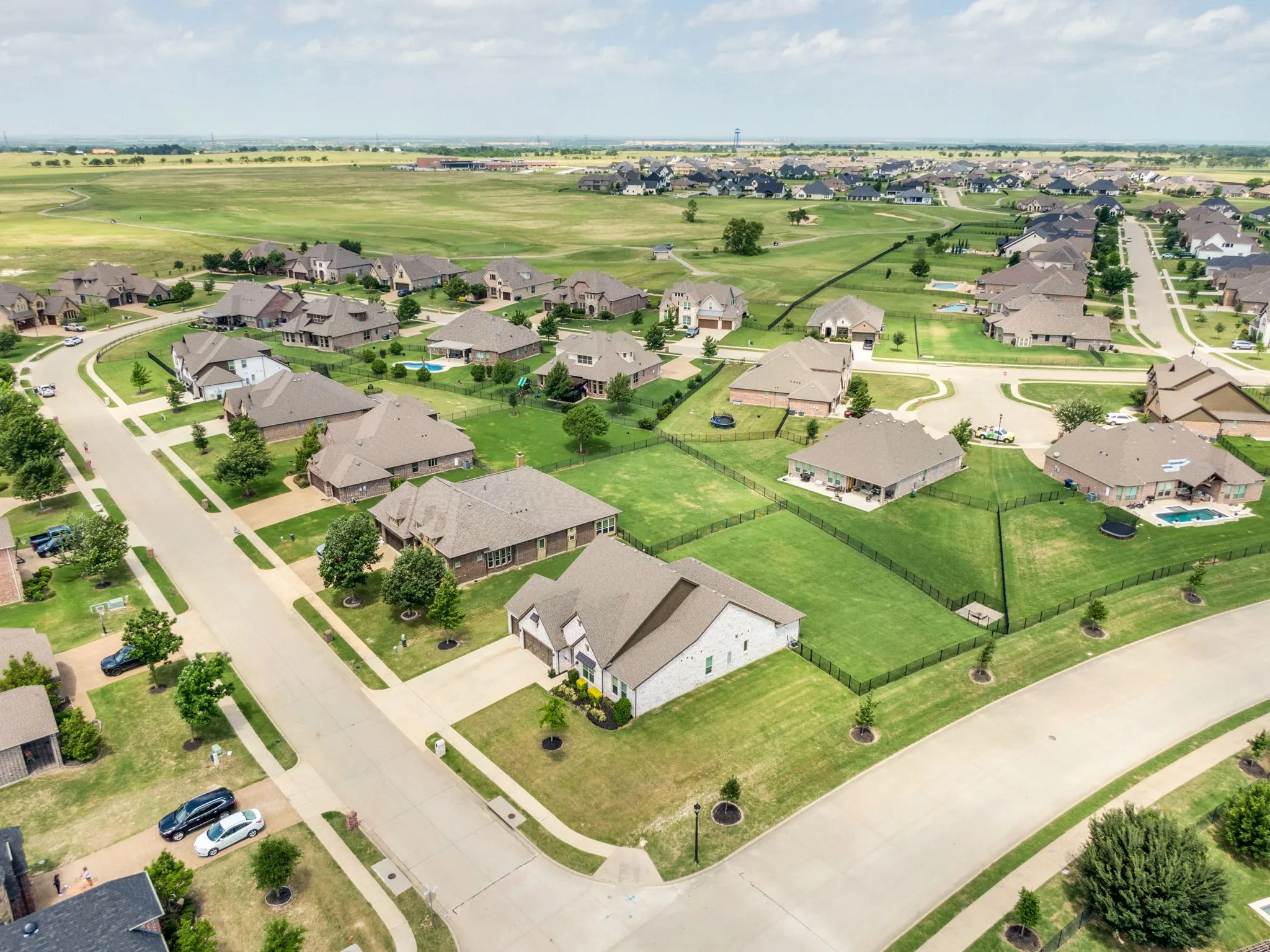 Residential neighborhood featuring a curvilinear street layout, mature landscaping, and uniform architectural styles