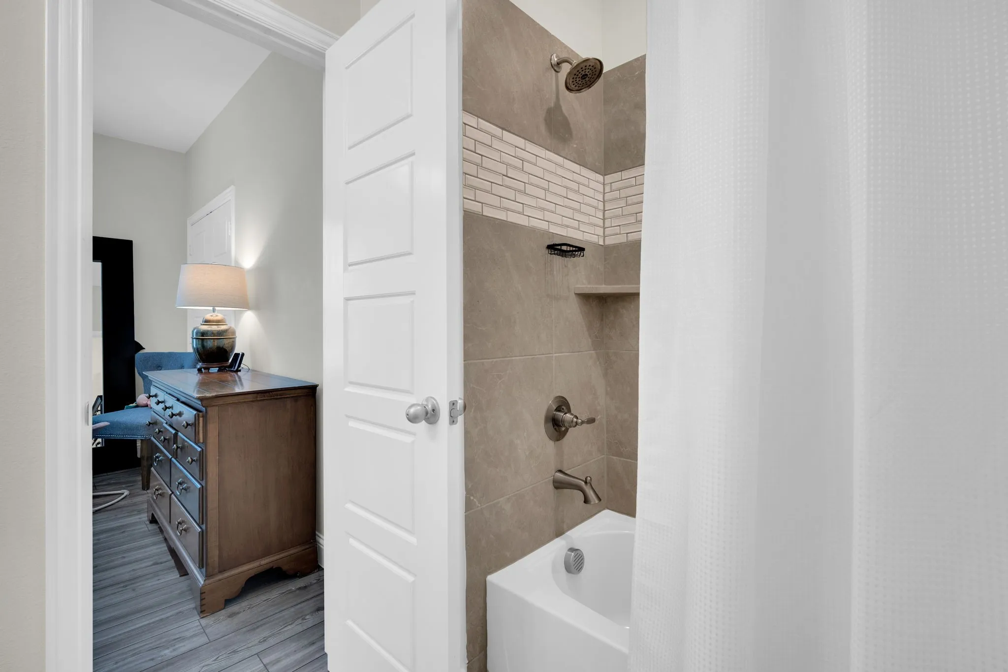 Ensuite Bathroom featuring a tub/shower combination with tile surround and an integrated shower niche
