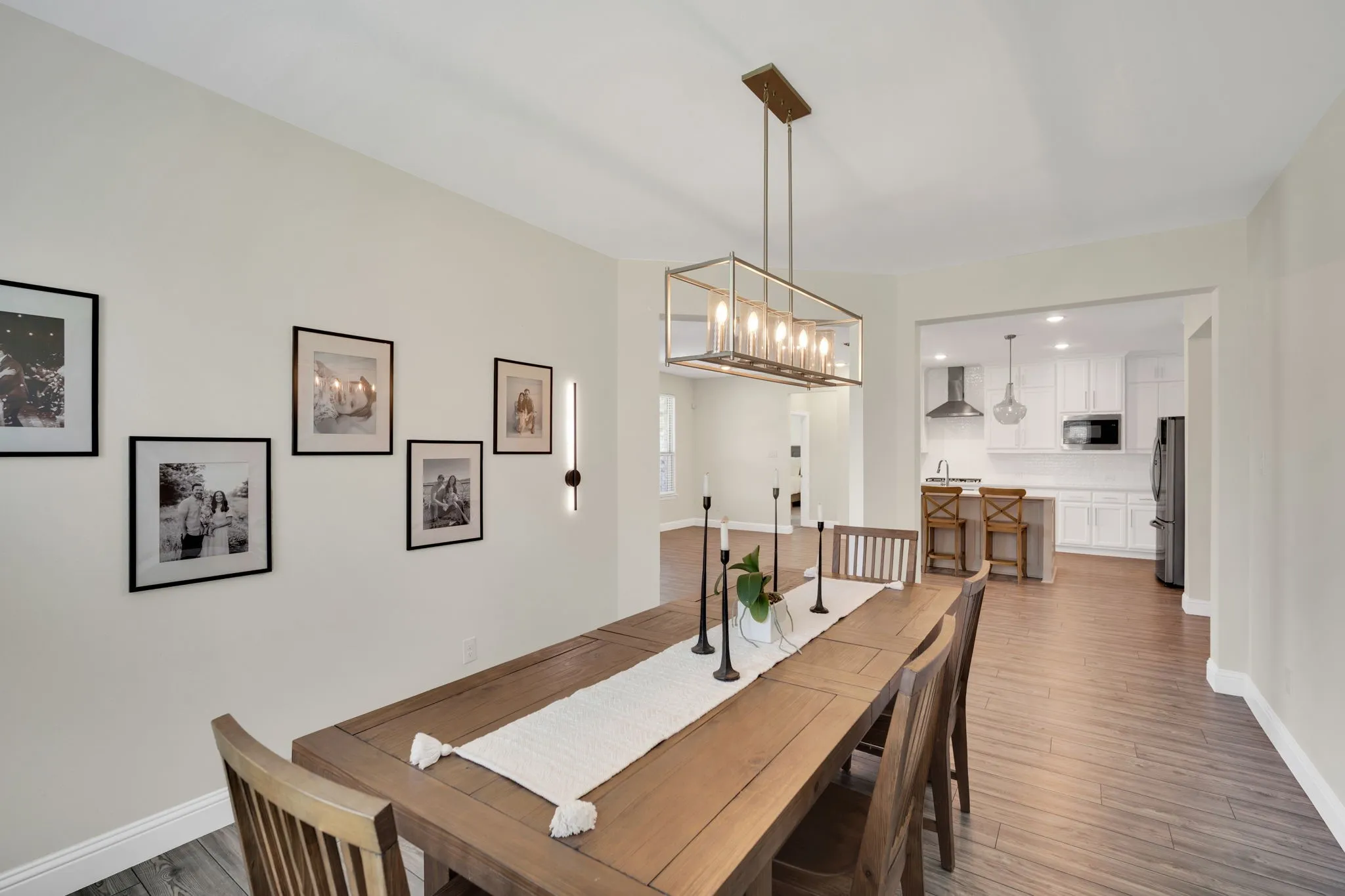 Dining area with wood-finish flooring, featuring a rectangular wood dining table and chairs