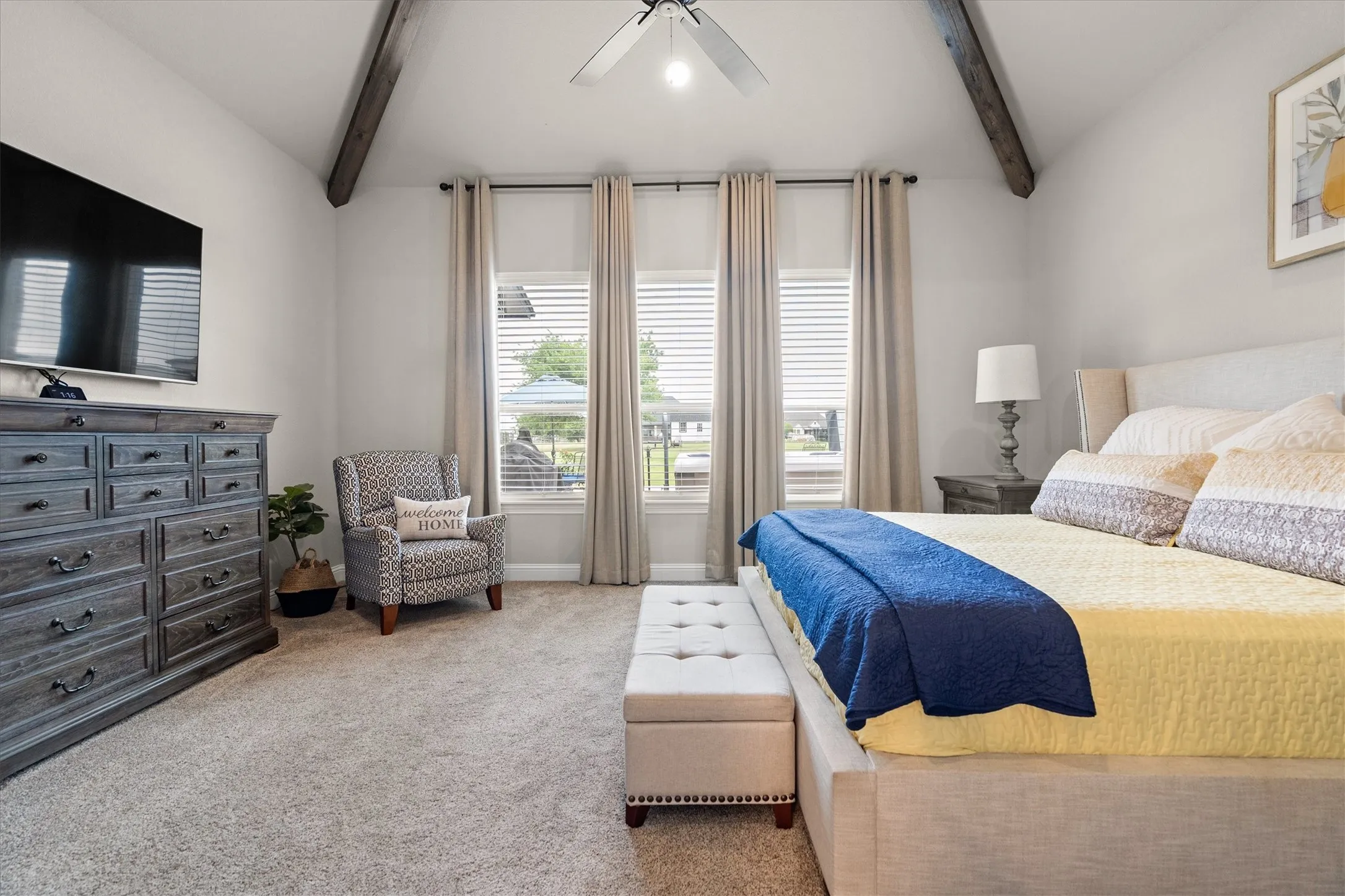 The primary bedroom has it's own wing, a vaulted ceiling, and exposed beams.