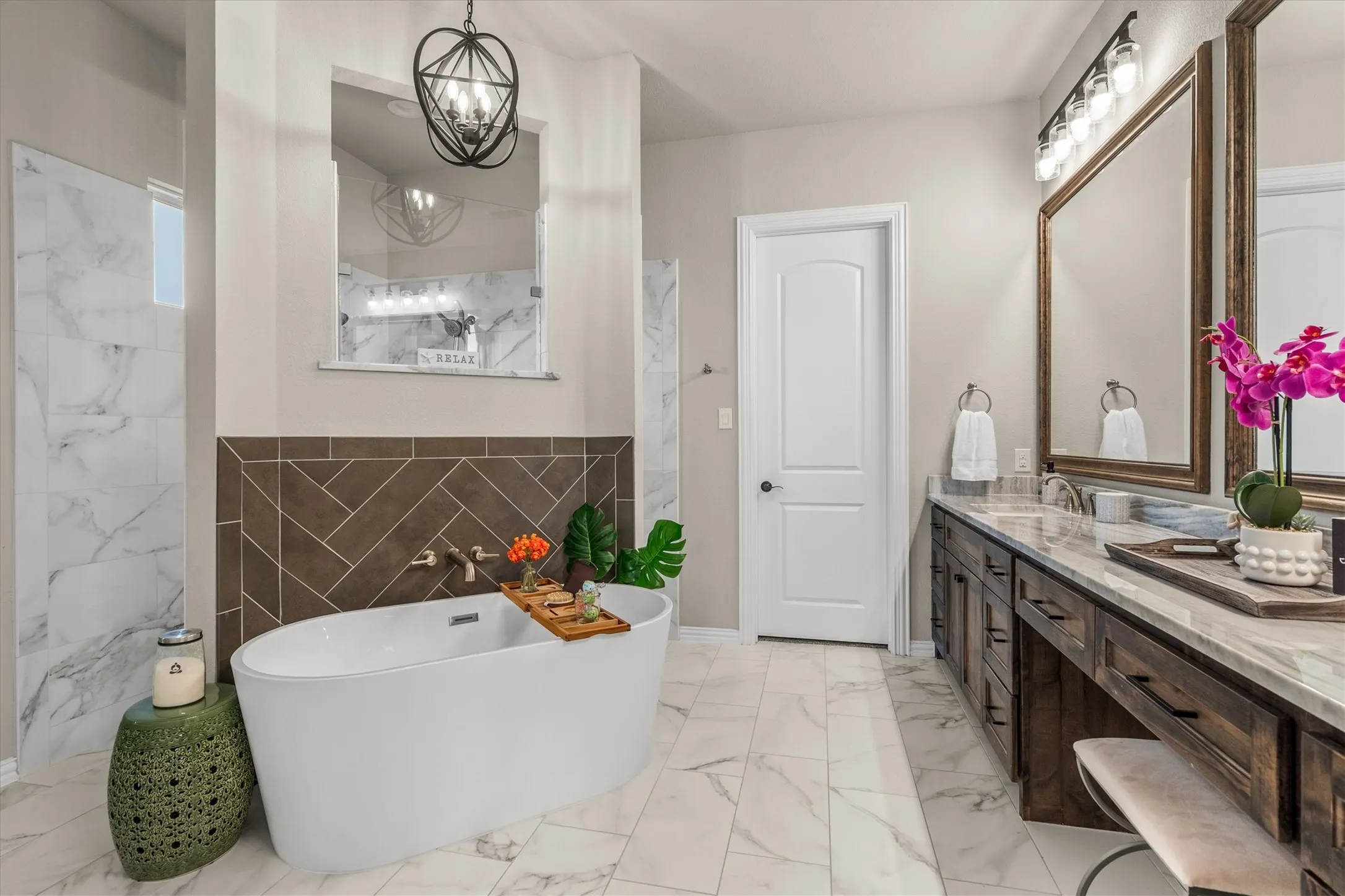 The nearly 200 square foot primary bathroom has a walk through double shower, standing bathtub, a 14 foot counter with makeup area and dual sinks and connects to the closet which connects to the laundry room.