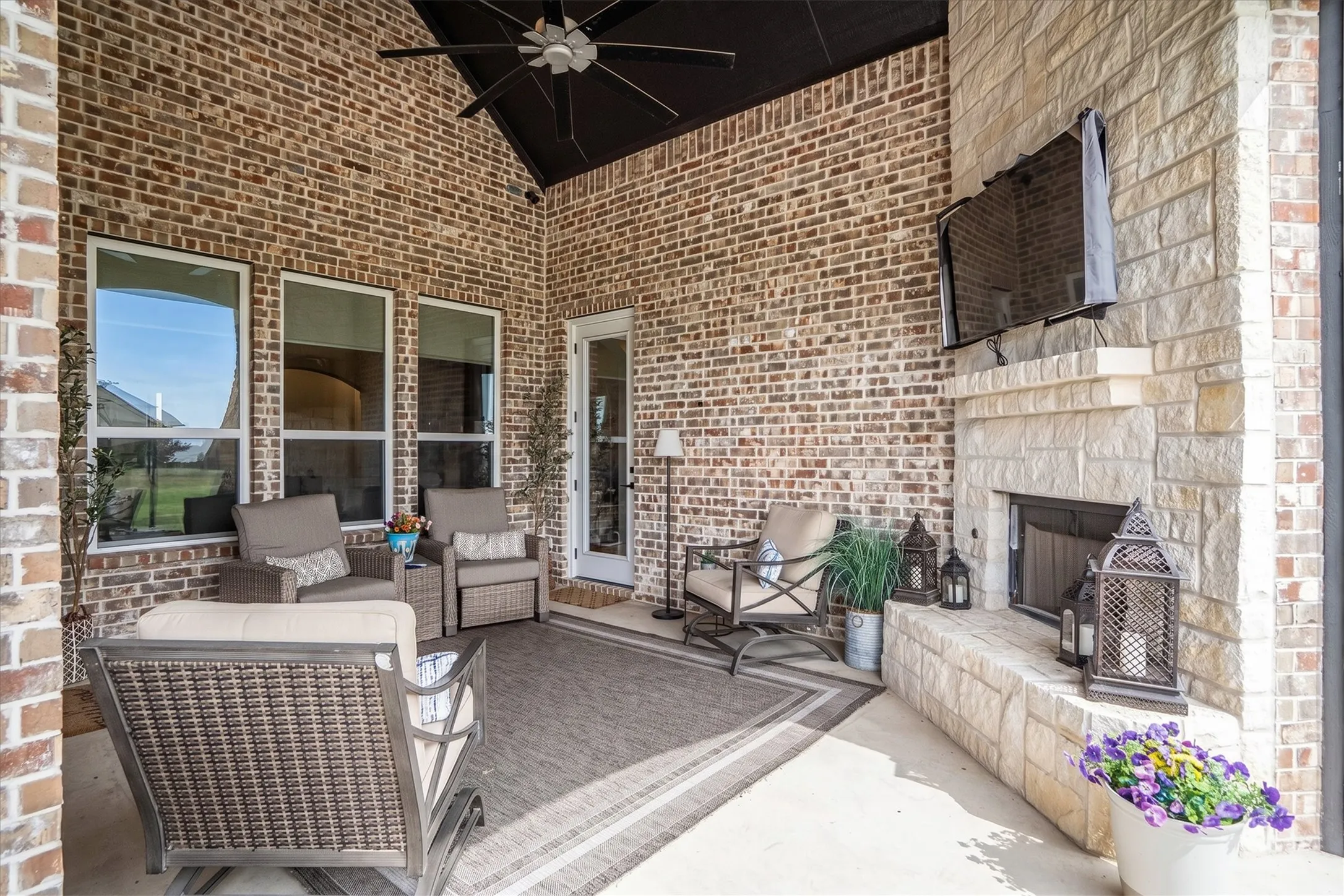 The back patio is accessible from two sides of the property and has a propane stone fireplace with a hearth.