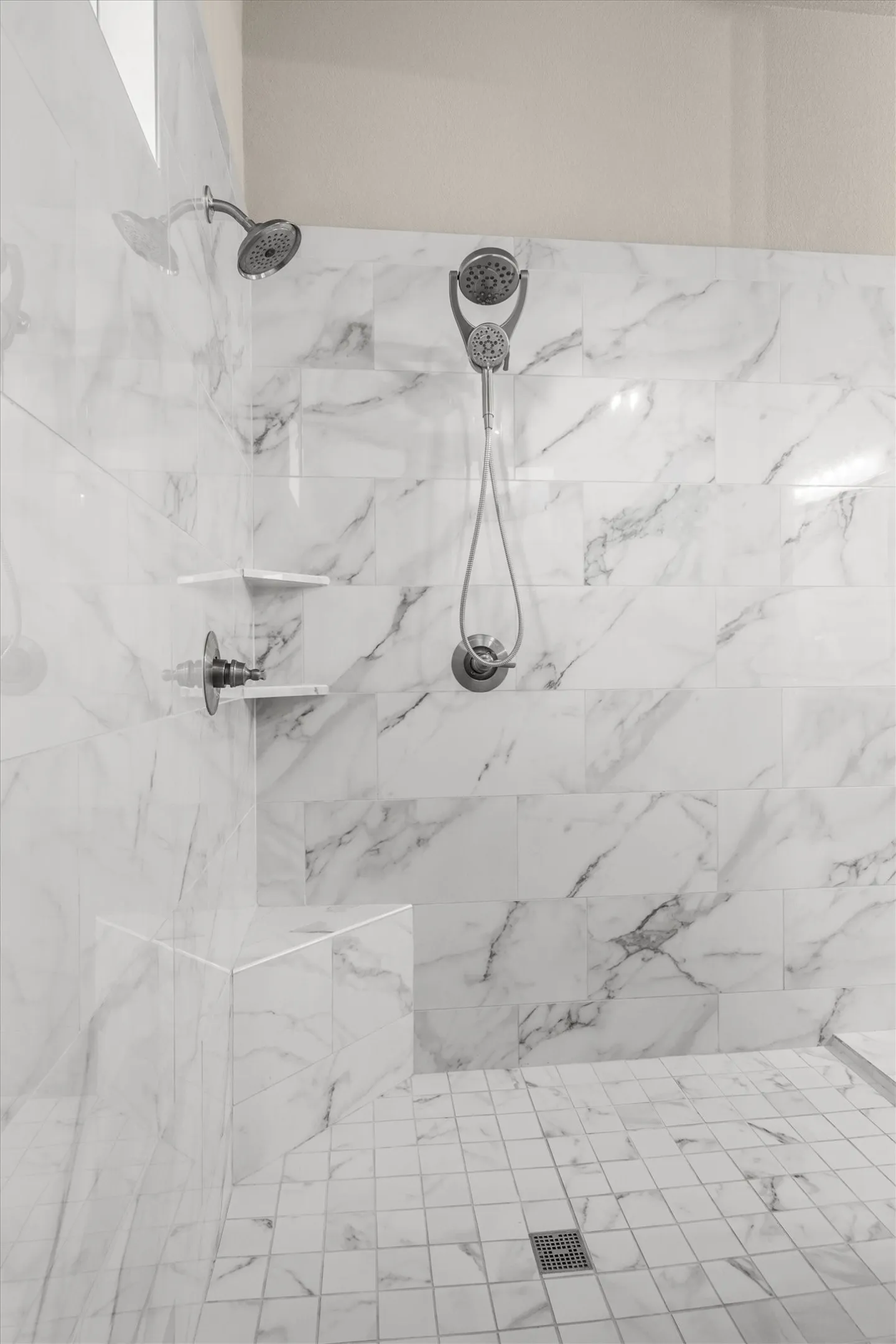 The spacious primary shower has two shower heads.