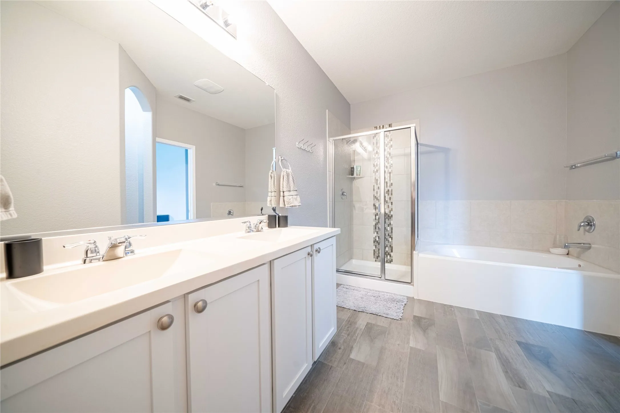 Bathroom featuring independent shower and bath and double vanity