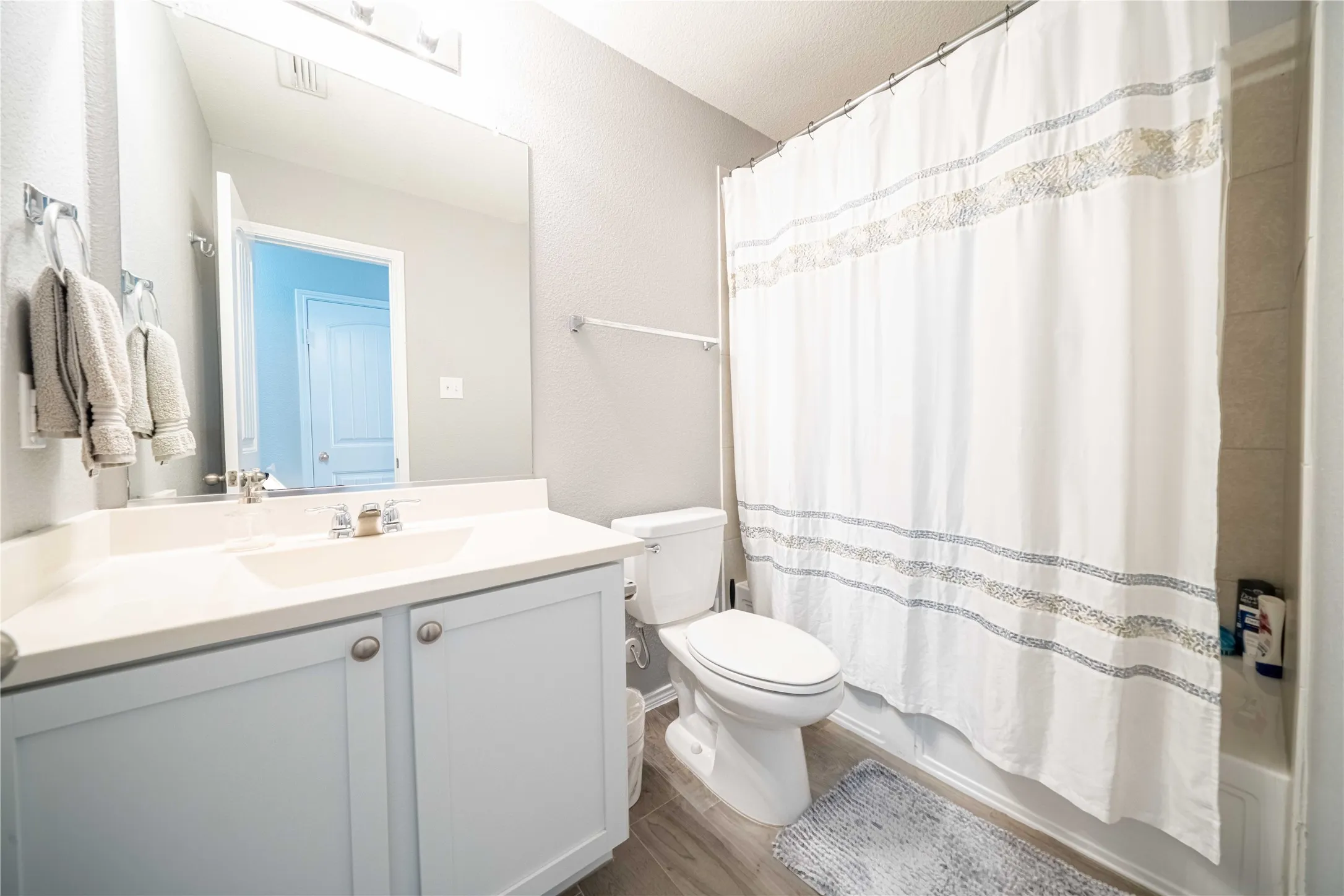 Bathroom with vanity, toilet, and wood-type flooring