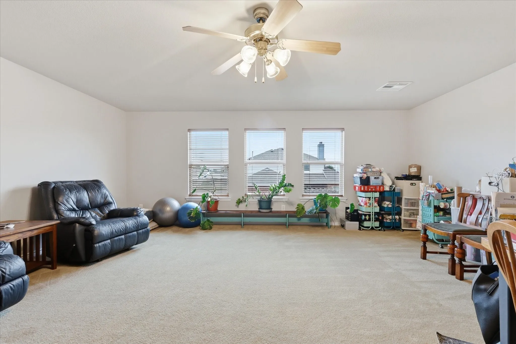 Upstairs Flex Room featuring windows at back of house, ceiling fan, attic entry.