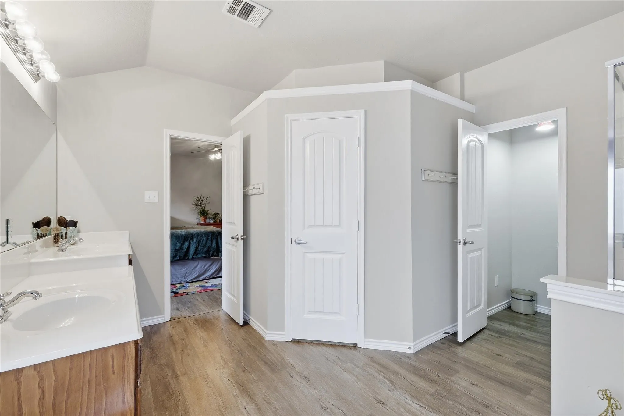 Primary Bath featuring walk in closet and private toilet room with door.