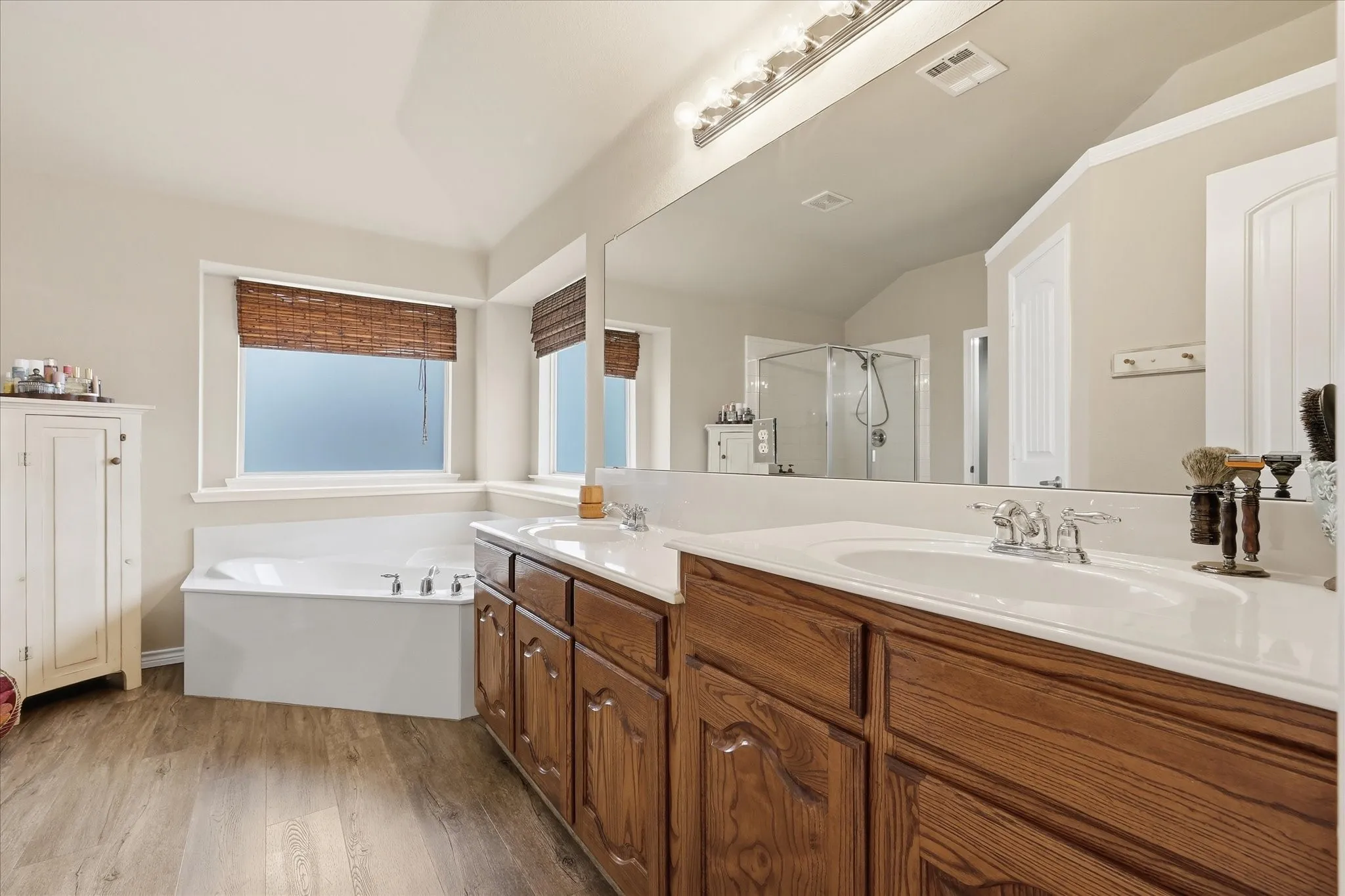 Primary Bath featuring dual level double vanity & garden tub with windows
