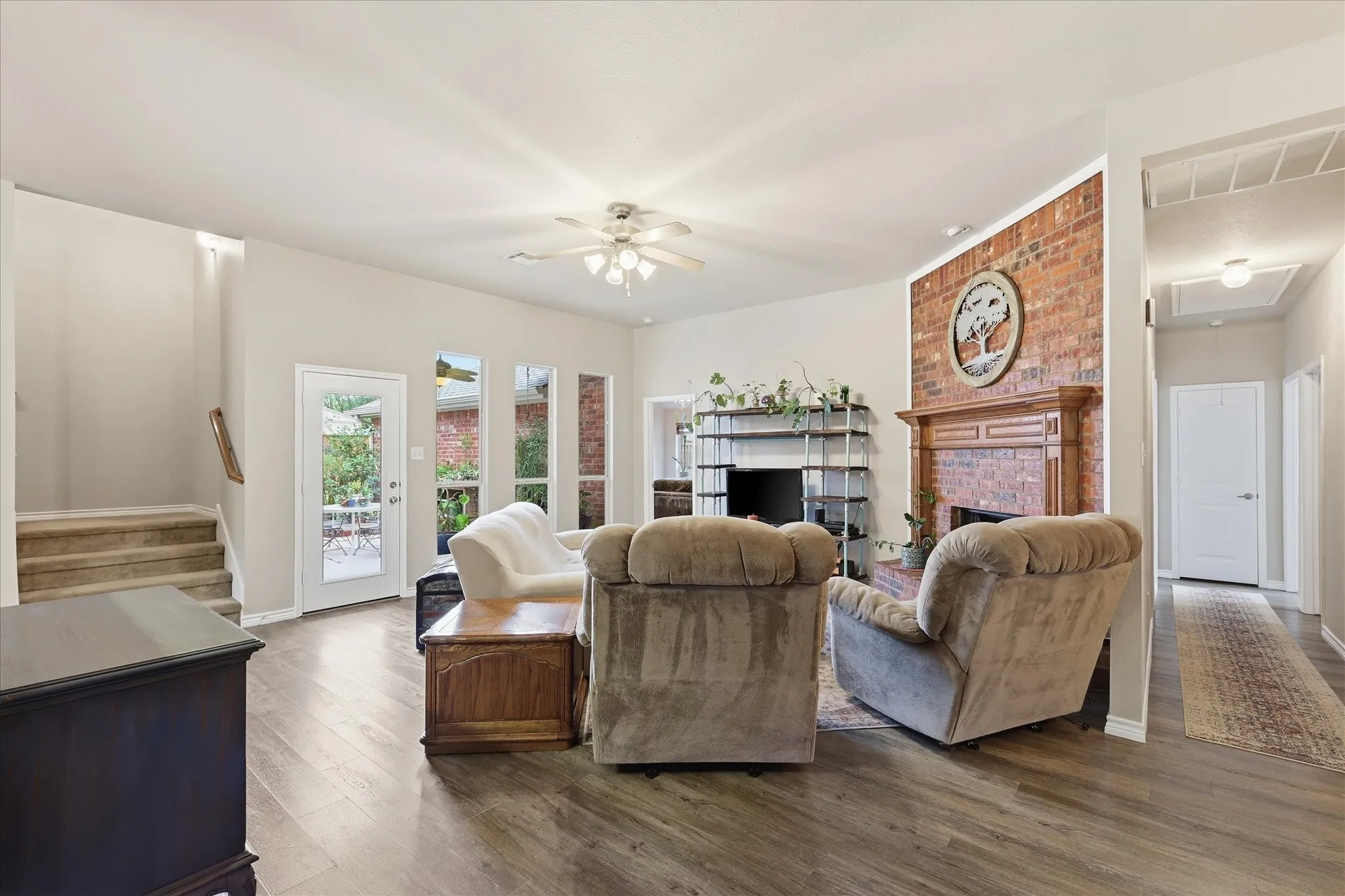 Spacious family room highlighted by a striking floor-to-ceiling brick fireplace with gas logs & large windows beaming with natural light.