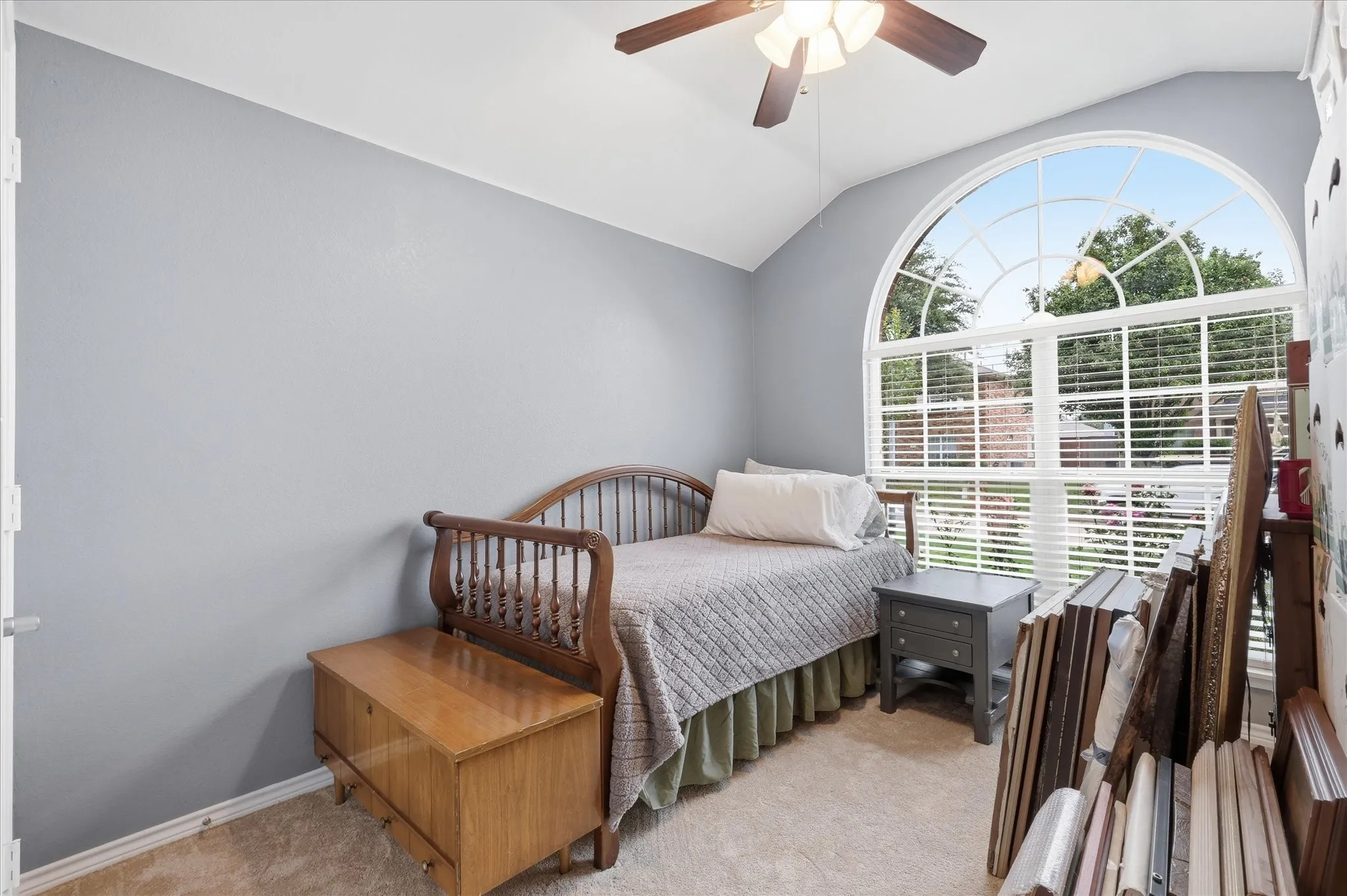 Secondary Bedroom at front of house featuring large window & ceiling fan.