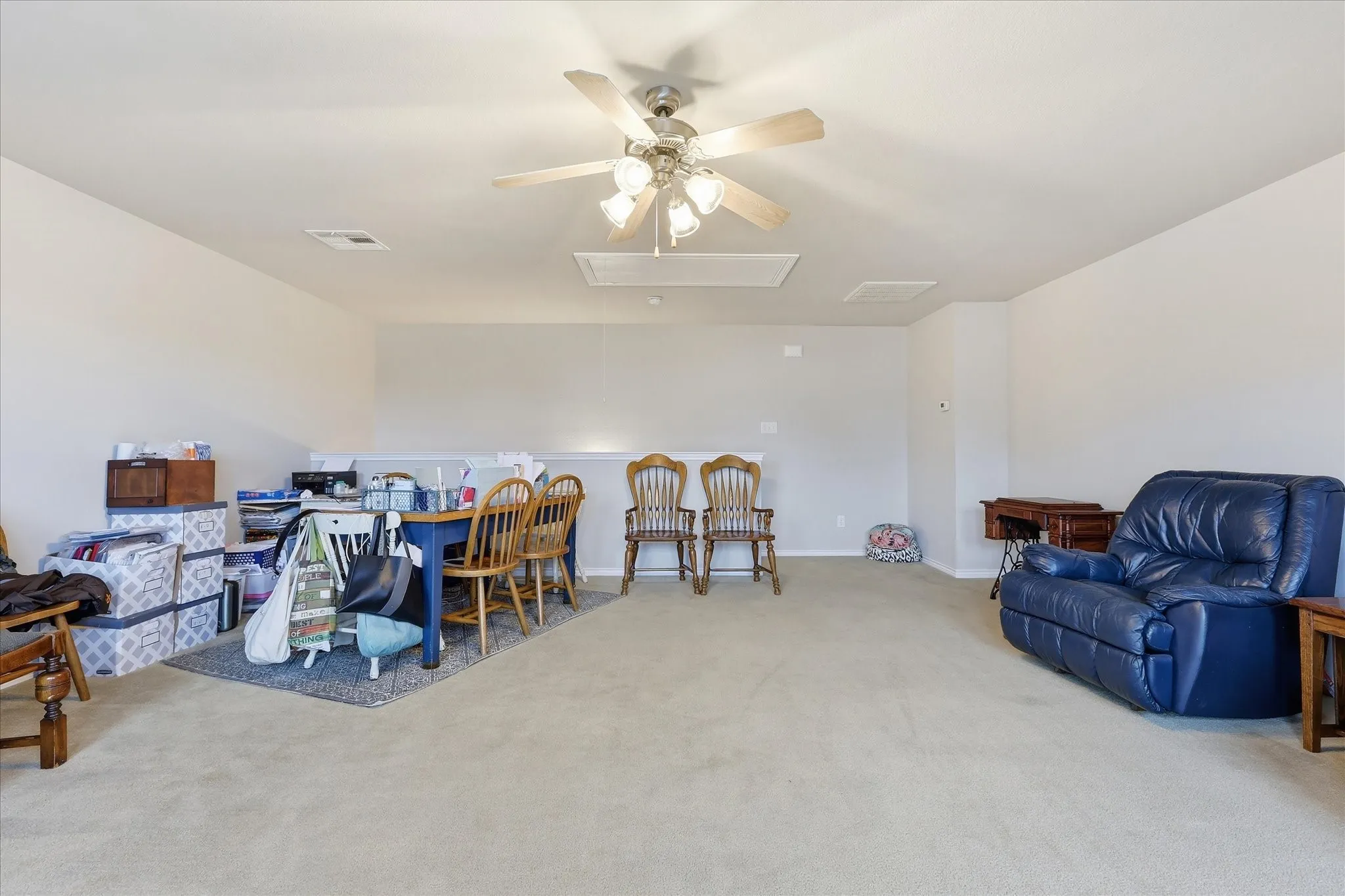 Upstairs Flex Room featuring windows at back of house, ceiling fan, attic entry.