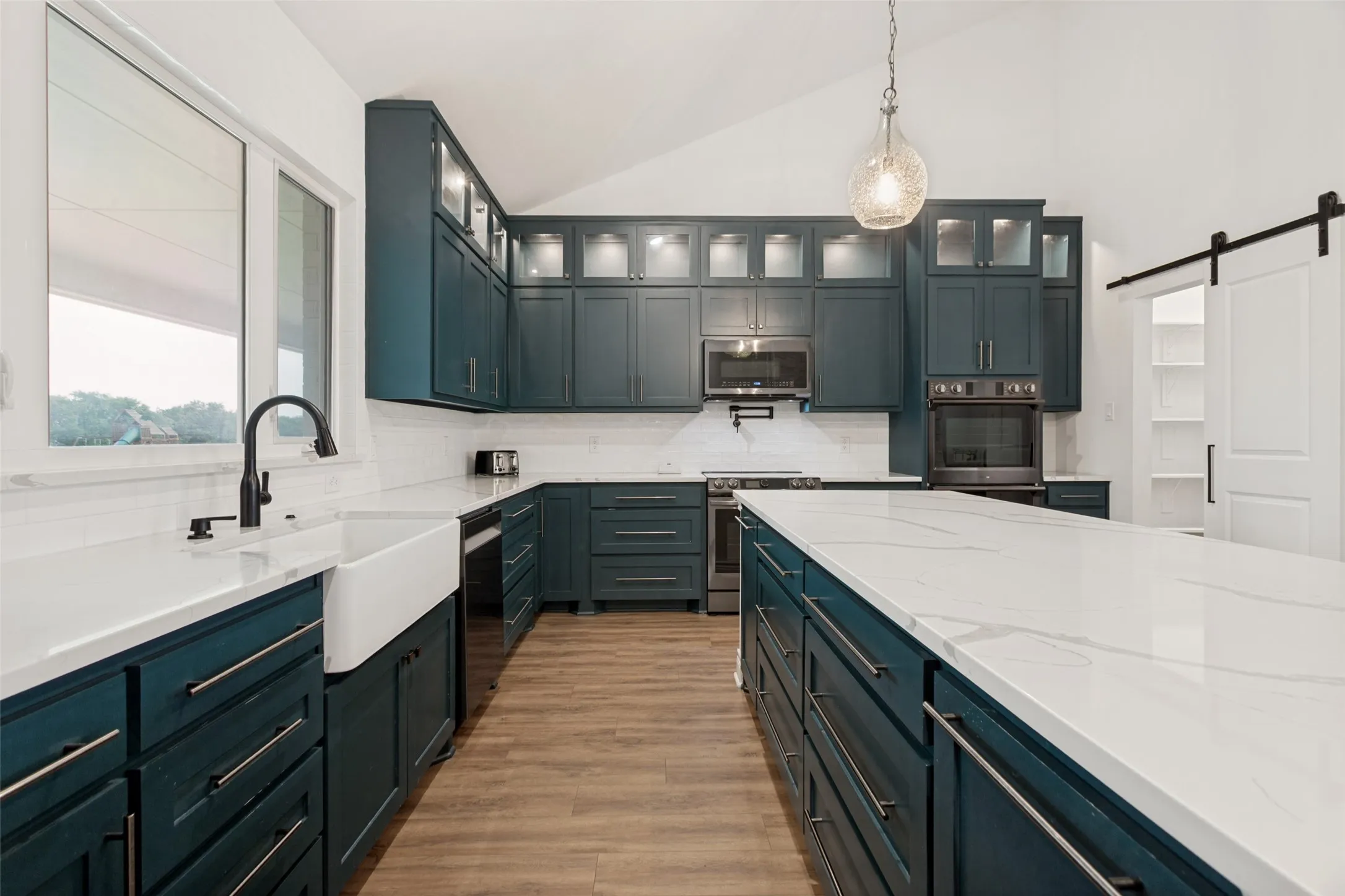 Another kitchen view showing the custom cabinetry, spacious layout, and beautiful upper, lighted display cabinets