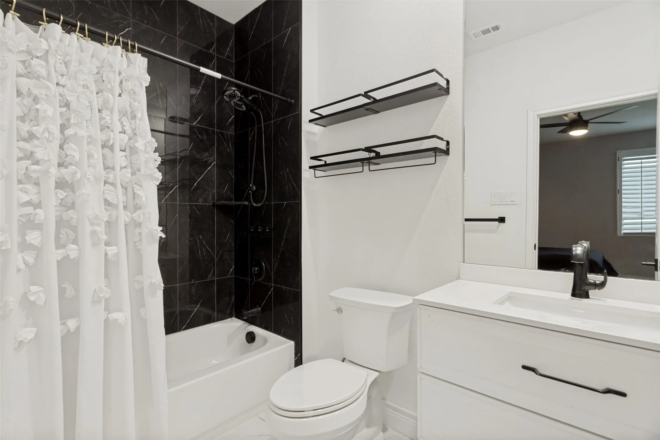 En-suite bathroom for secondary bedroom with attractive modern hardware, plumbing fixtures, and striking tub-shower tile