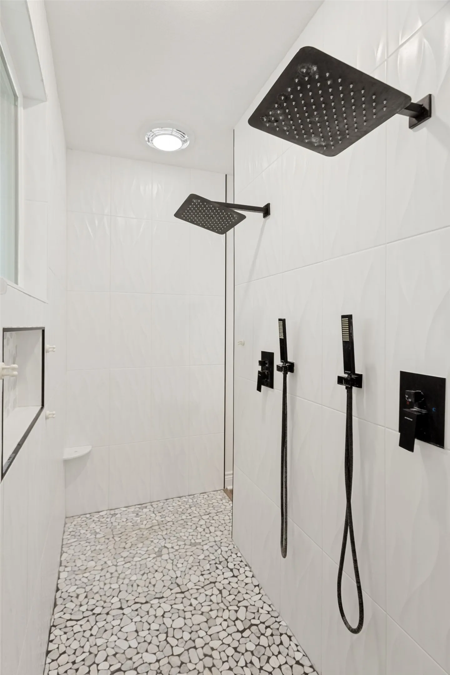 Very large walk in shower with two entry points and double rain shower heads, body sprays and controls.  Also note the beautiful tile floor!