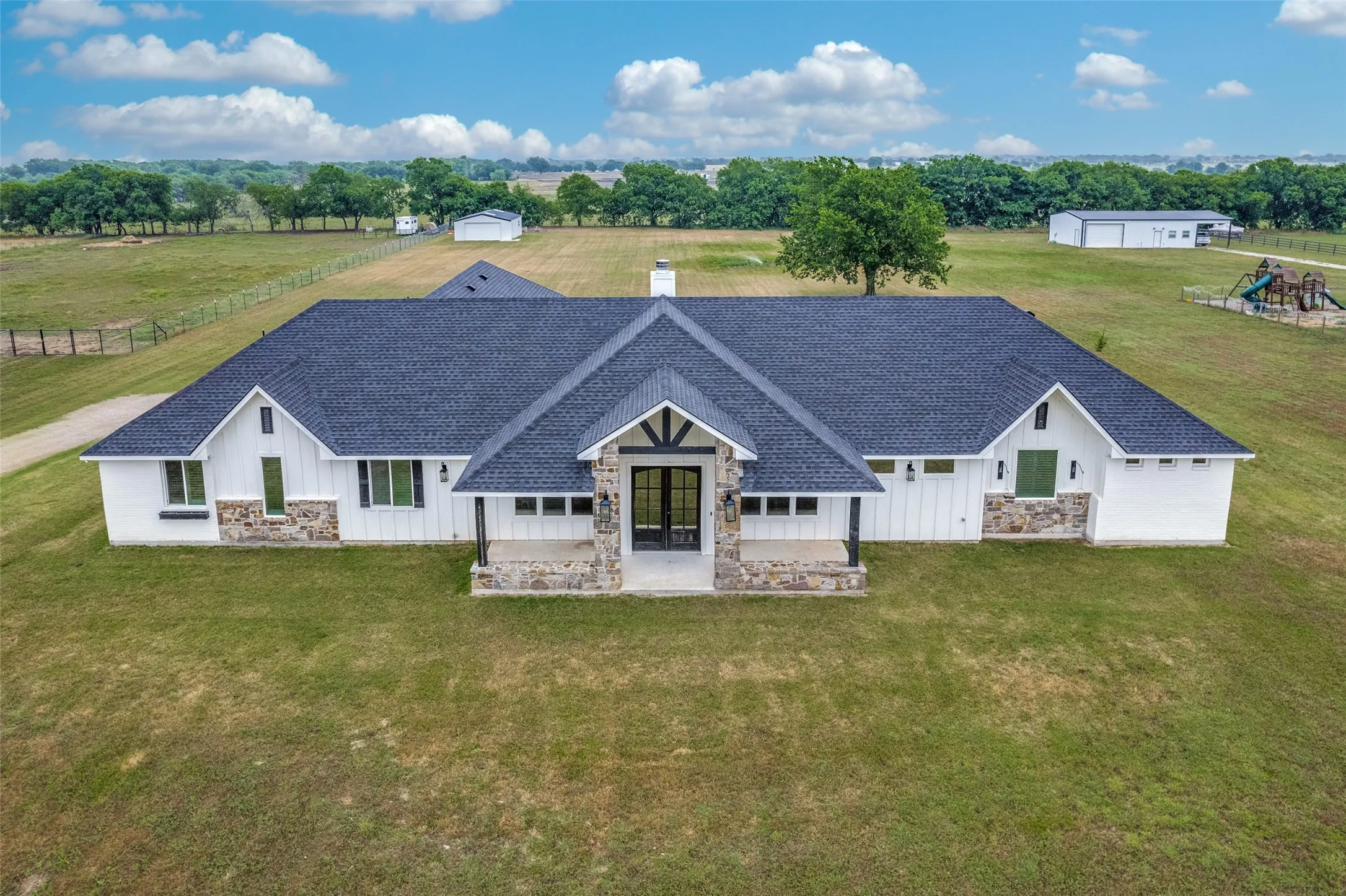 Aerial view of the front of the home showing beautiful architectural details and expansive rear space