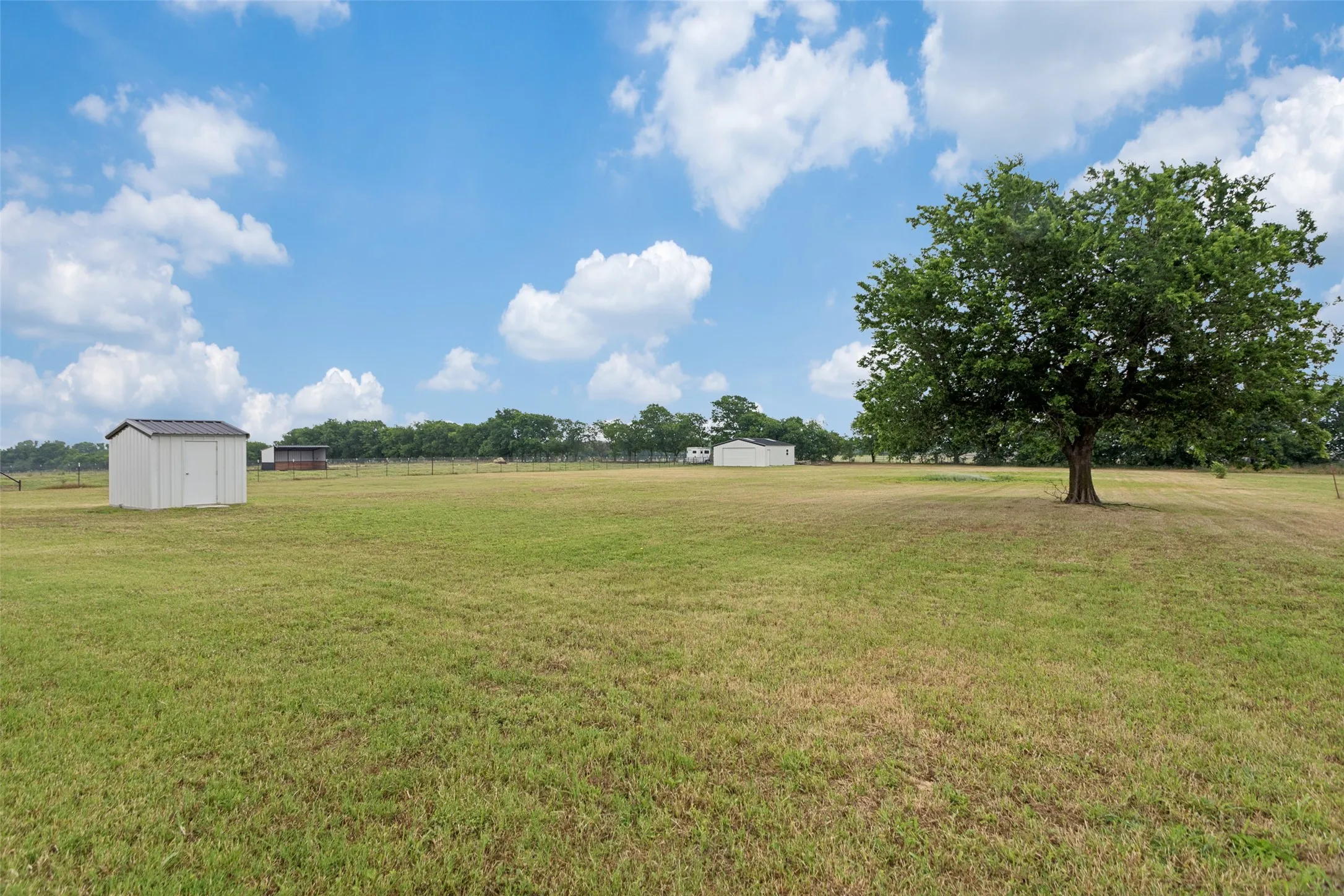 Two acre property with view of storage building and electric water well building with additional storage