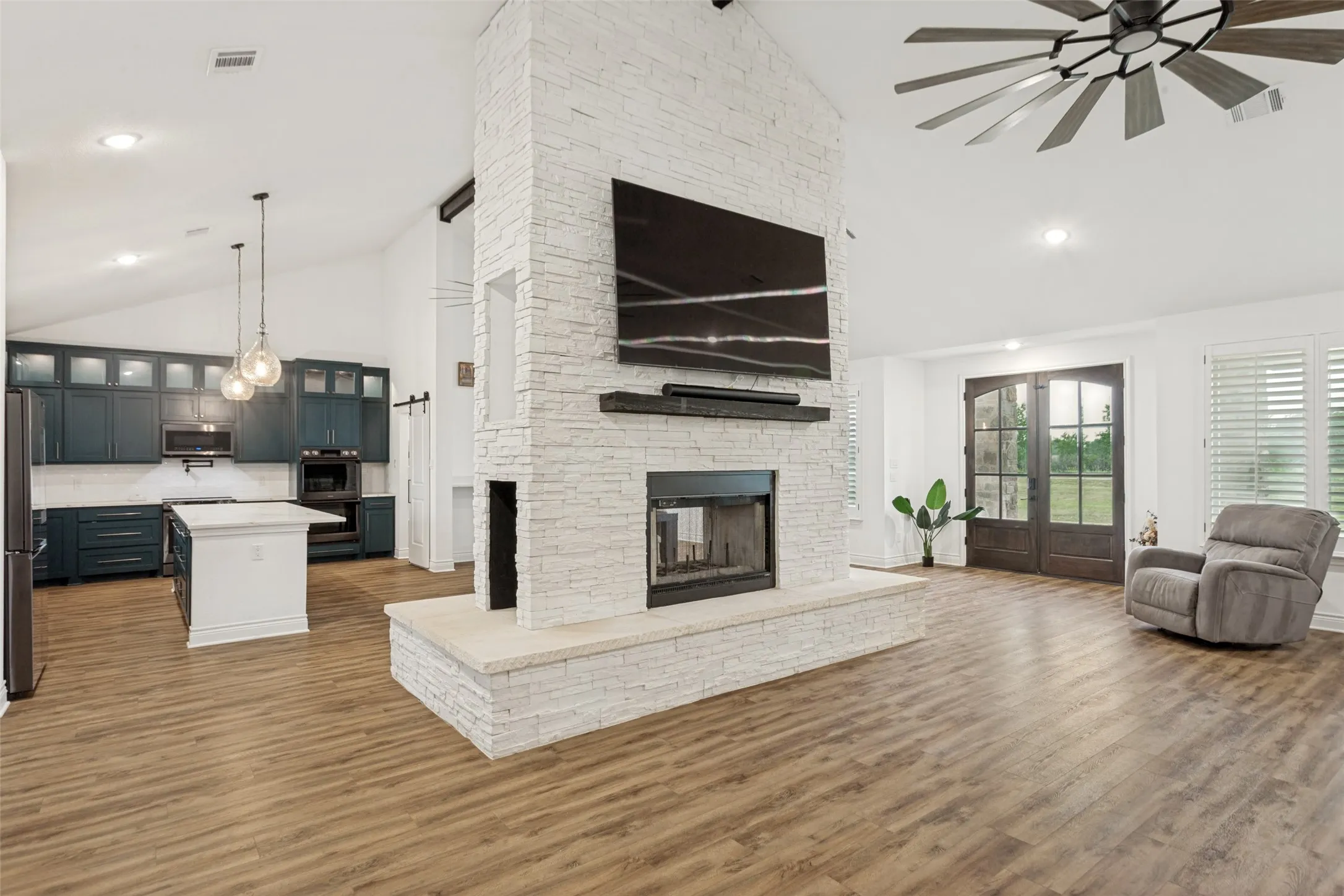 Partial view of living room and fireplace with view to the kitchen