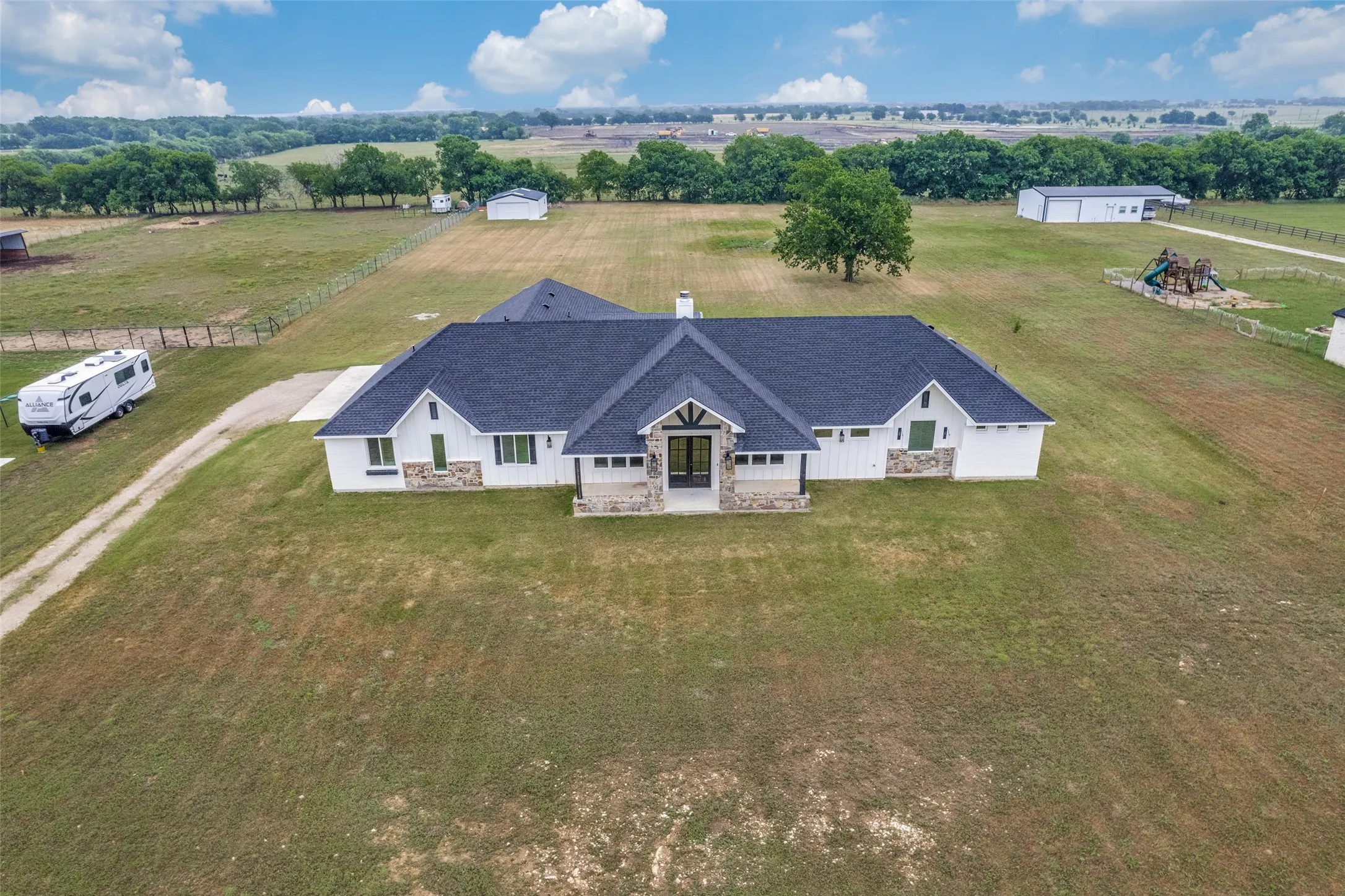 View of the two acre property from the front going back to the tree line in the distance
