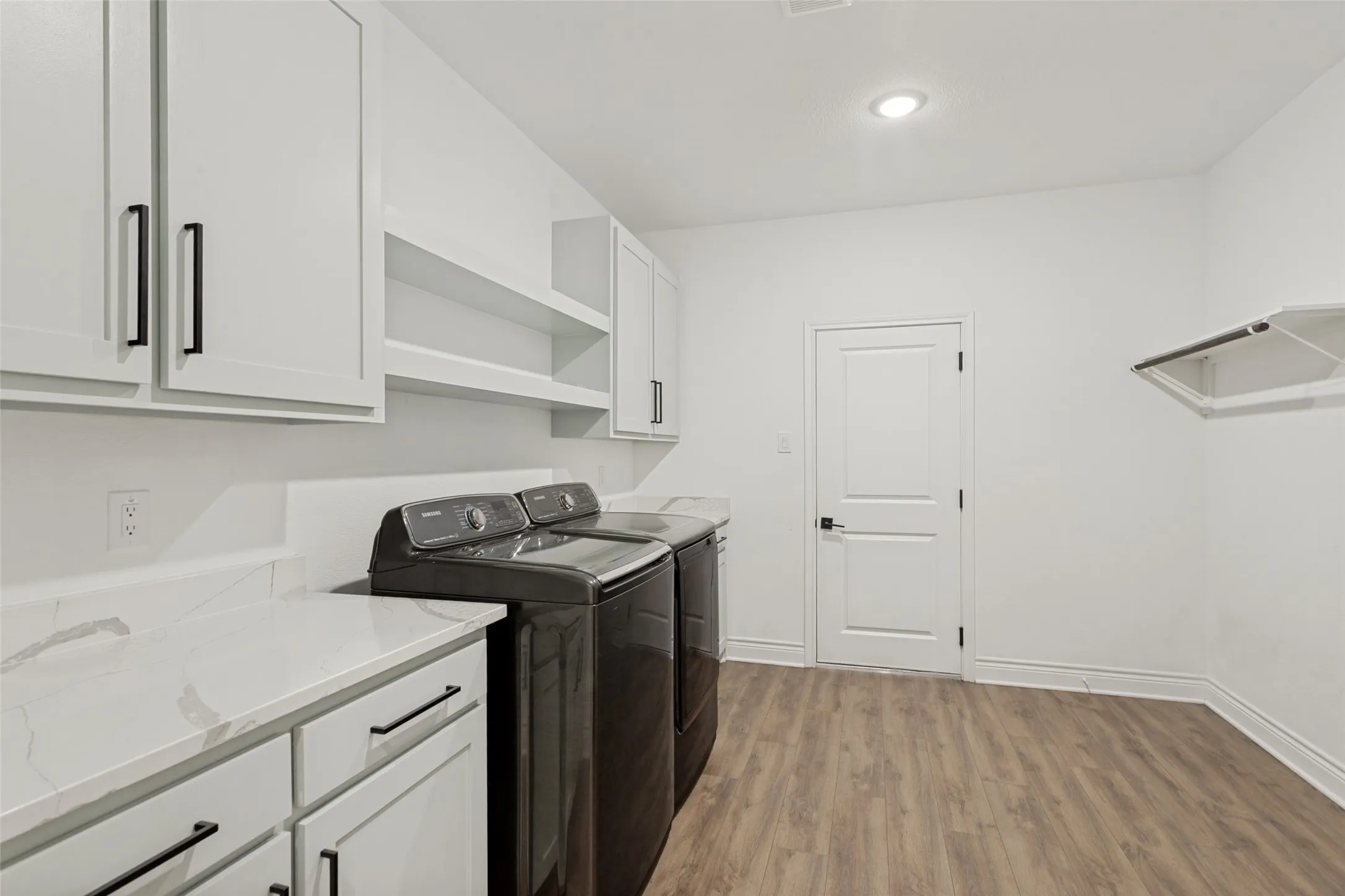 Very spacious laundry room with room for a refrigerator-freezer.  There are plenty of storage cabinets, a hanging rack for clothing and a handy built in ironing board!  The door leads to the oversized 3 car garage