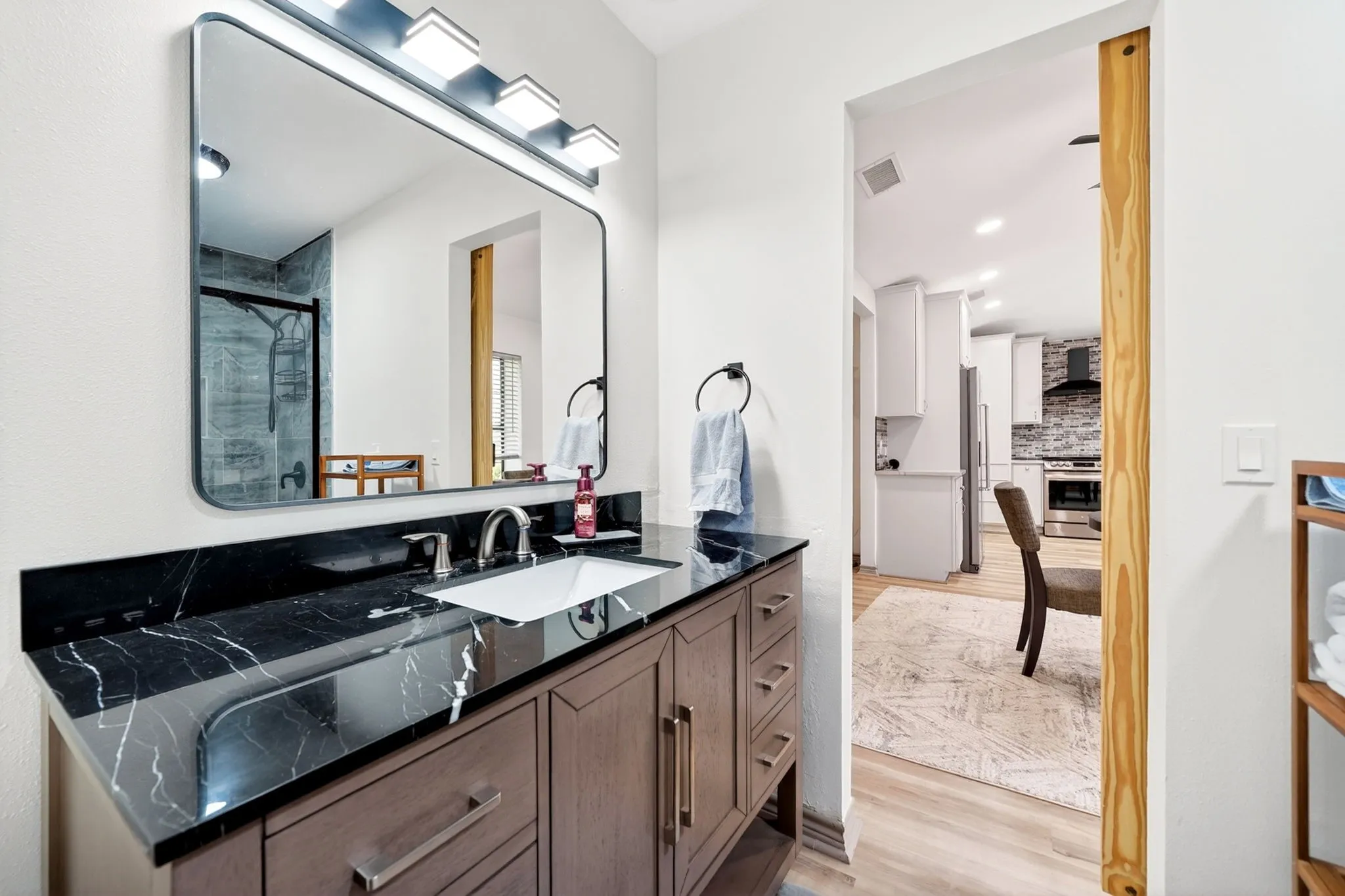Bathroom vanity with a dark marble-look countertop and integrated sink