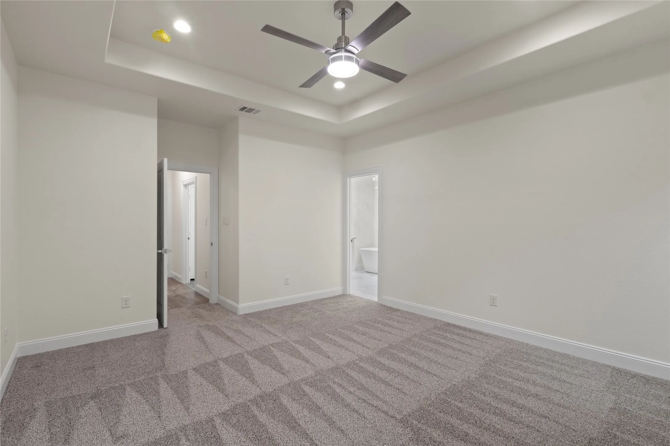Recessed lighting, tray ceiling, and a contemporary ceiling fan with integrated lighting