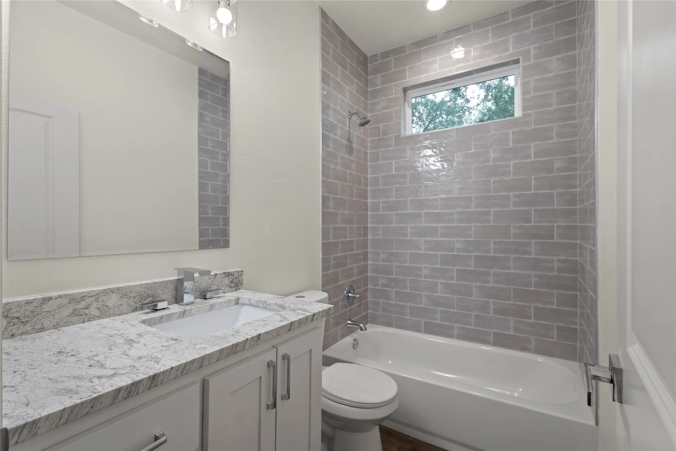 Bathroom featuring a white vanity with a granite-style countertop, undermount sink, and chrome fixtures