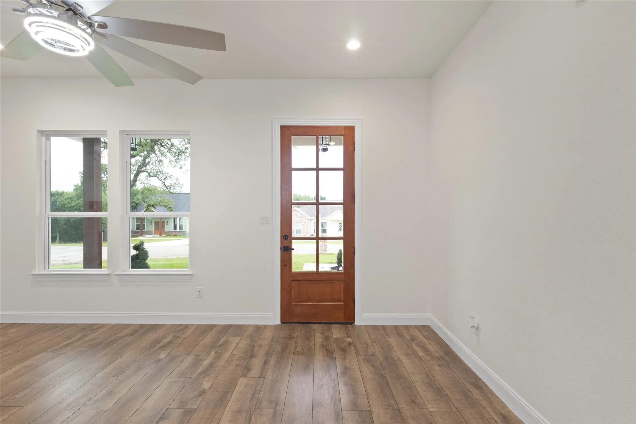 Warm wood-finish flooring complements a multi-paneled wooden door