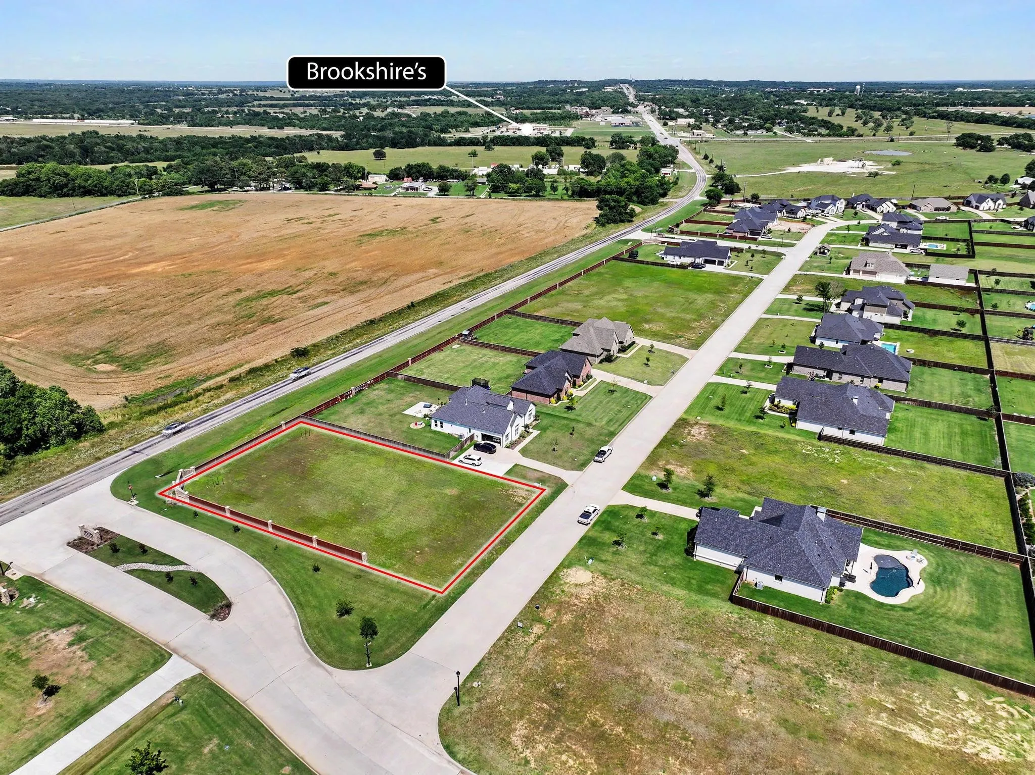 Expansive cleared lot outlined in red, featuring direct road frontage and a level topography