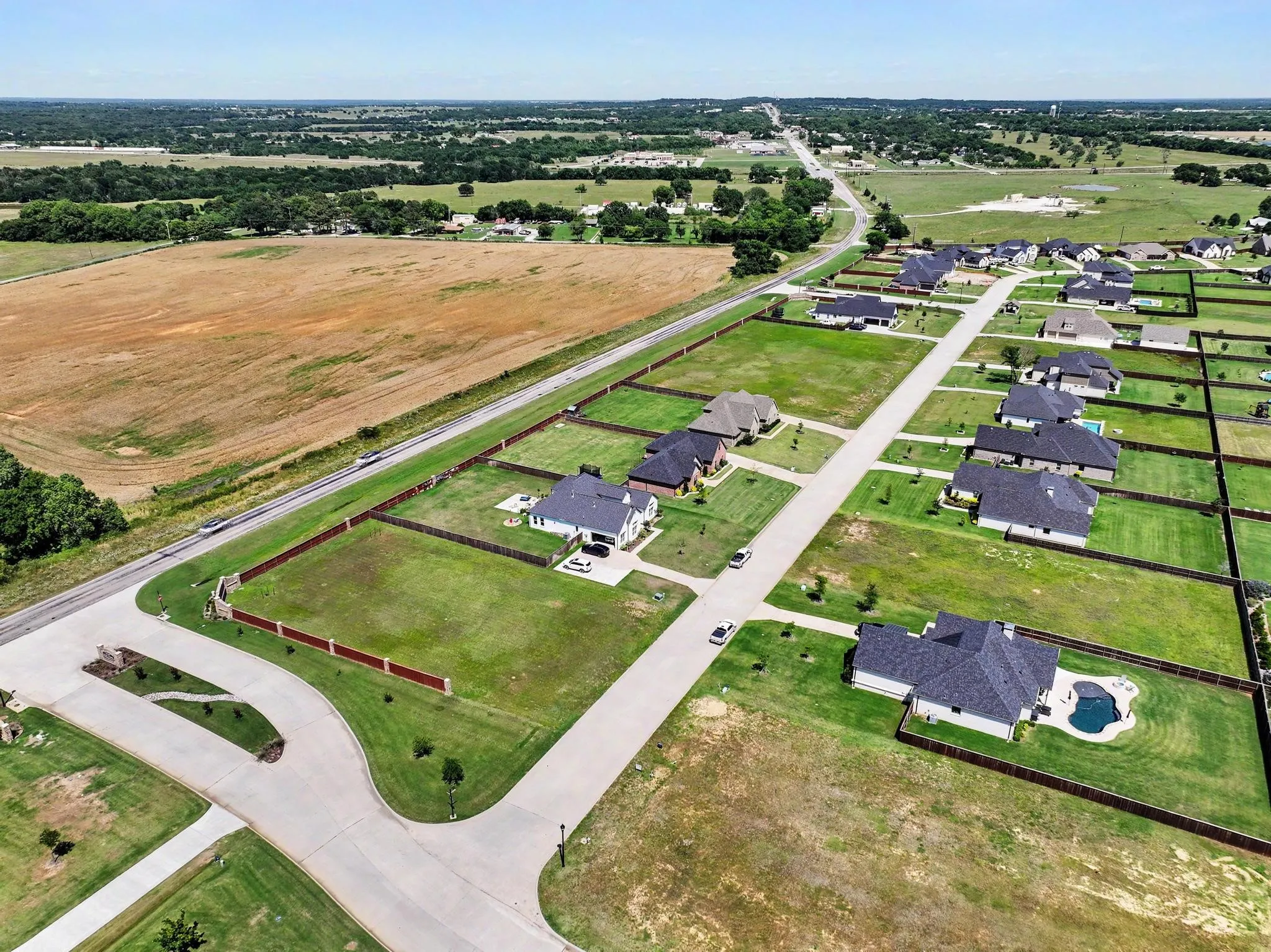 Aerial overview of a residential neighborhood with established homes on spacious lots, many featuring private swimming pools
