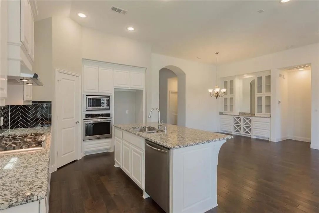 Kitchen featuring a central island with granite countertop and double-basin sink