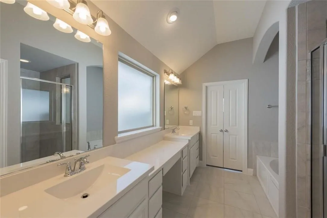 Bathroom featuring a dual vanity with white countertops, chrome fixtures, and undermount sinks