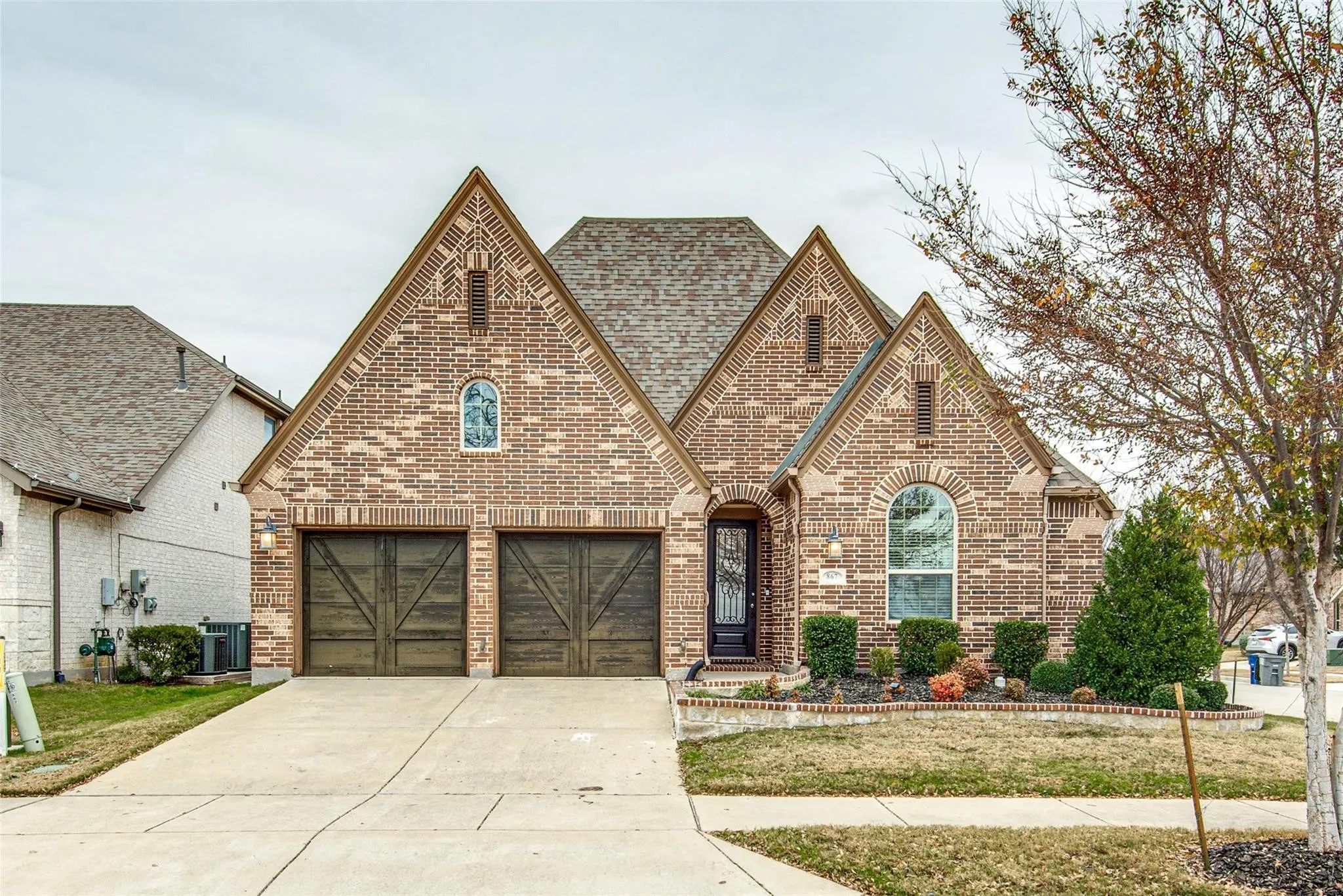 Traditional brick exterior featuring multiple gables and a composition shingle roof